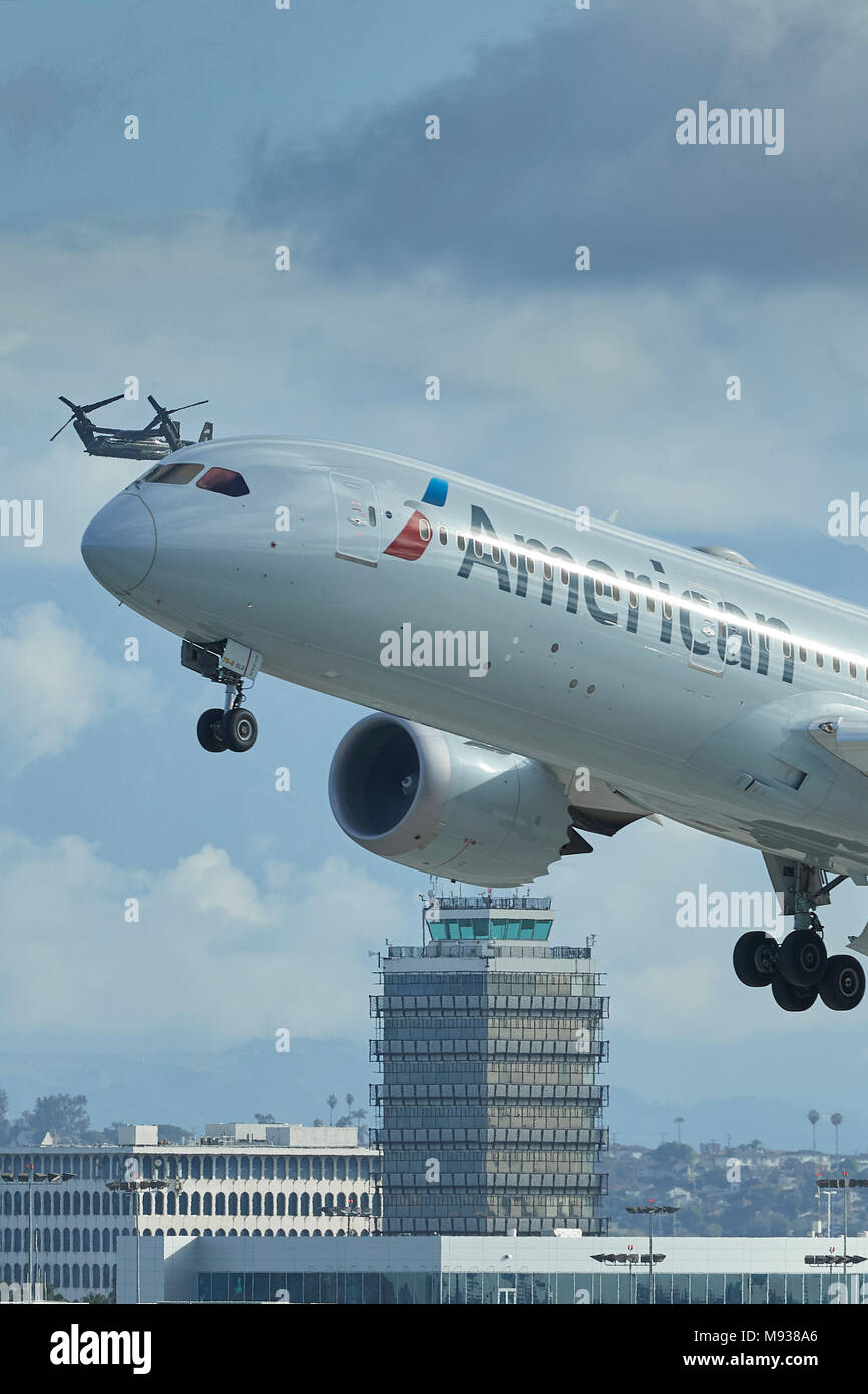 American Airlines Boeing 787-900 Dreamliner Taking Off From LAX, Los Angeles Airport, US Marine Corps V-22 Osprey Escorting President Trump Behind. Stock Photo