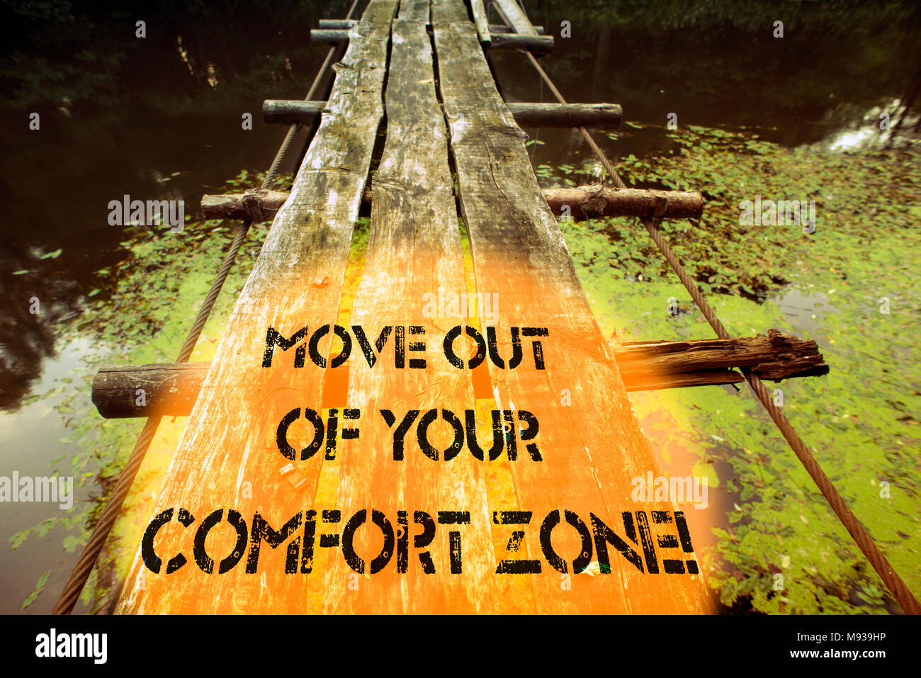 move out of your comfort zone written with ruined wooden bridge fragment over forest river waters Stock Photo