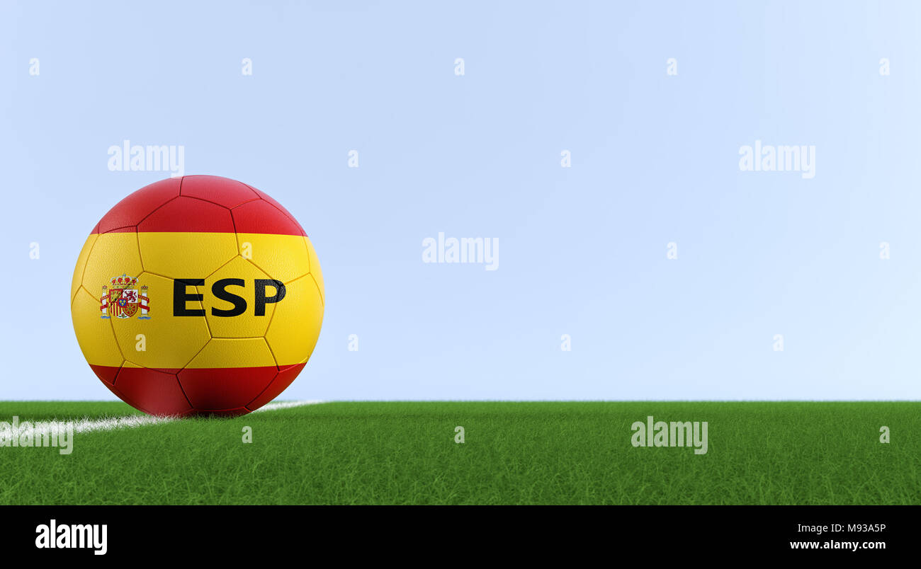 Soccer ball in spanish national colors on a soccer field. Copy space on