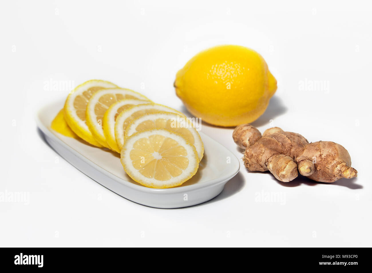 Studio photography of Lemon slices and Lemon fruit with Ginger root isolated on a white background. Healthy ingredients for common cold cure medicine Stock Photo