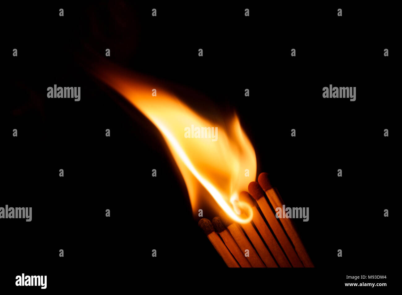 A row of matches is being ignited, spreading the fire Stock Photo
