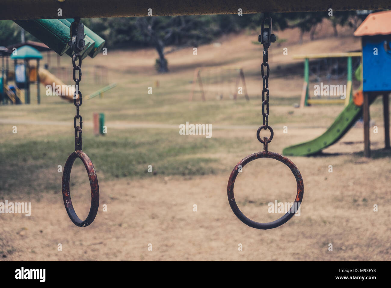 rings hanging on climbing frame - vintage outdoor playground - Stock Photo