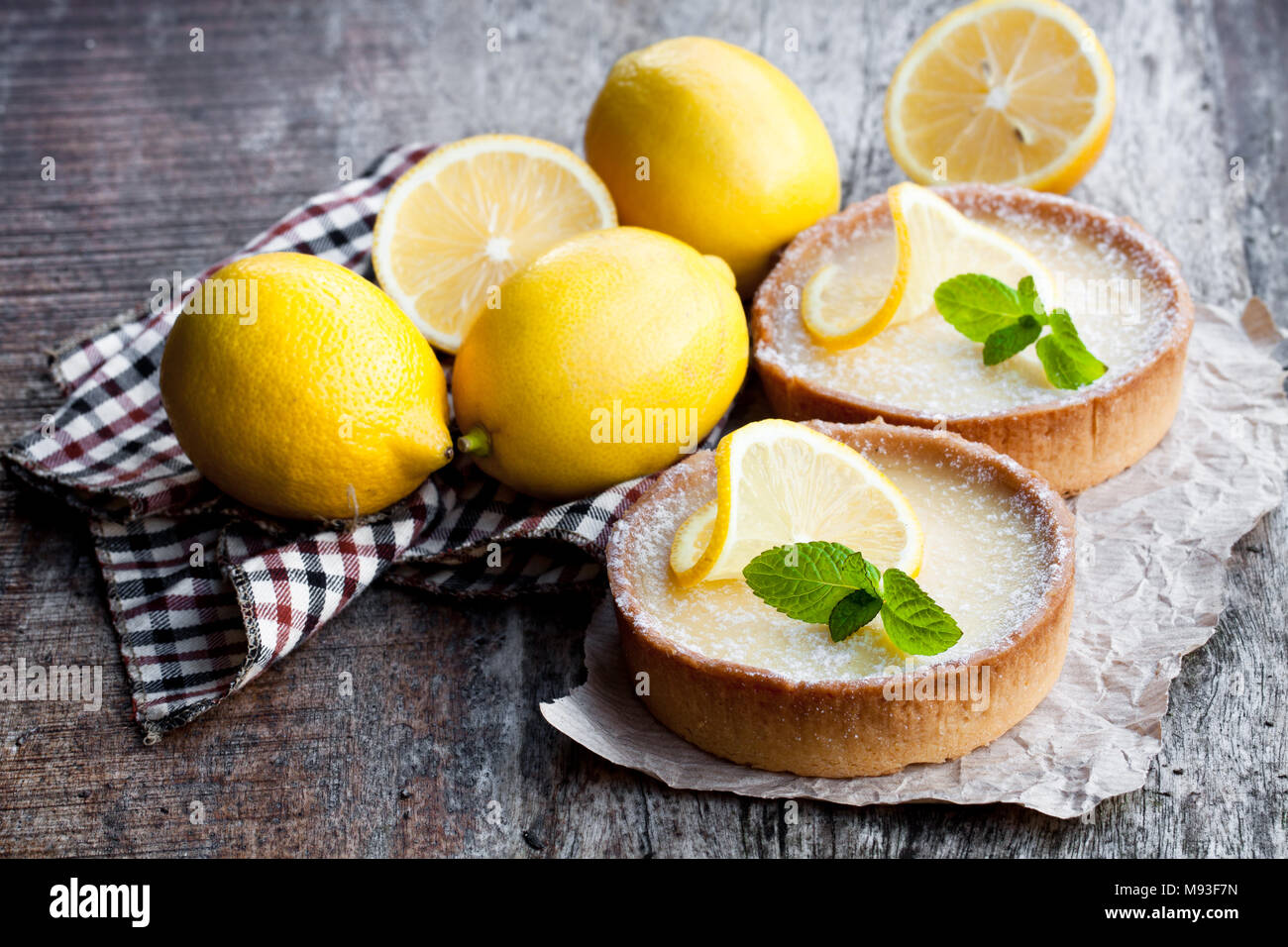 Mini lemon tarts on wooden table Stock Photo