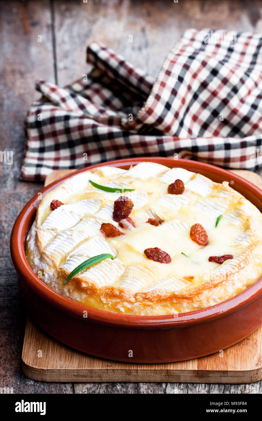 Delicious  hot baked camembert with sultanas on wooden table Stock Photo