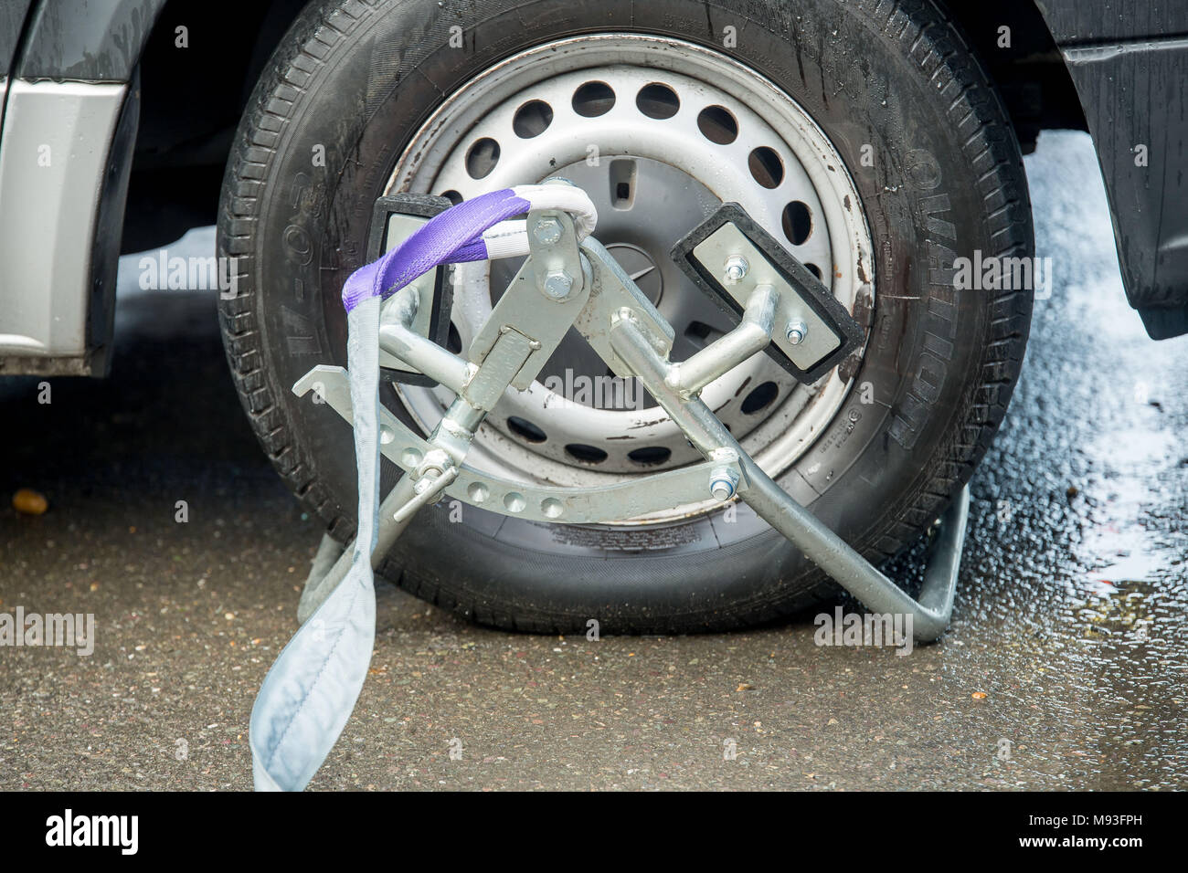 Wheel clamping of untaxed vehicles is becoming more common with the paper tax disc display being abolished and car tax needing to be paid online. Stock Photo