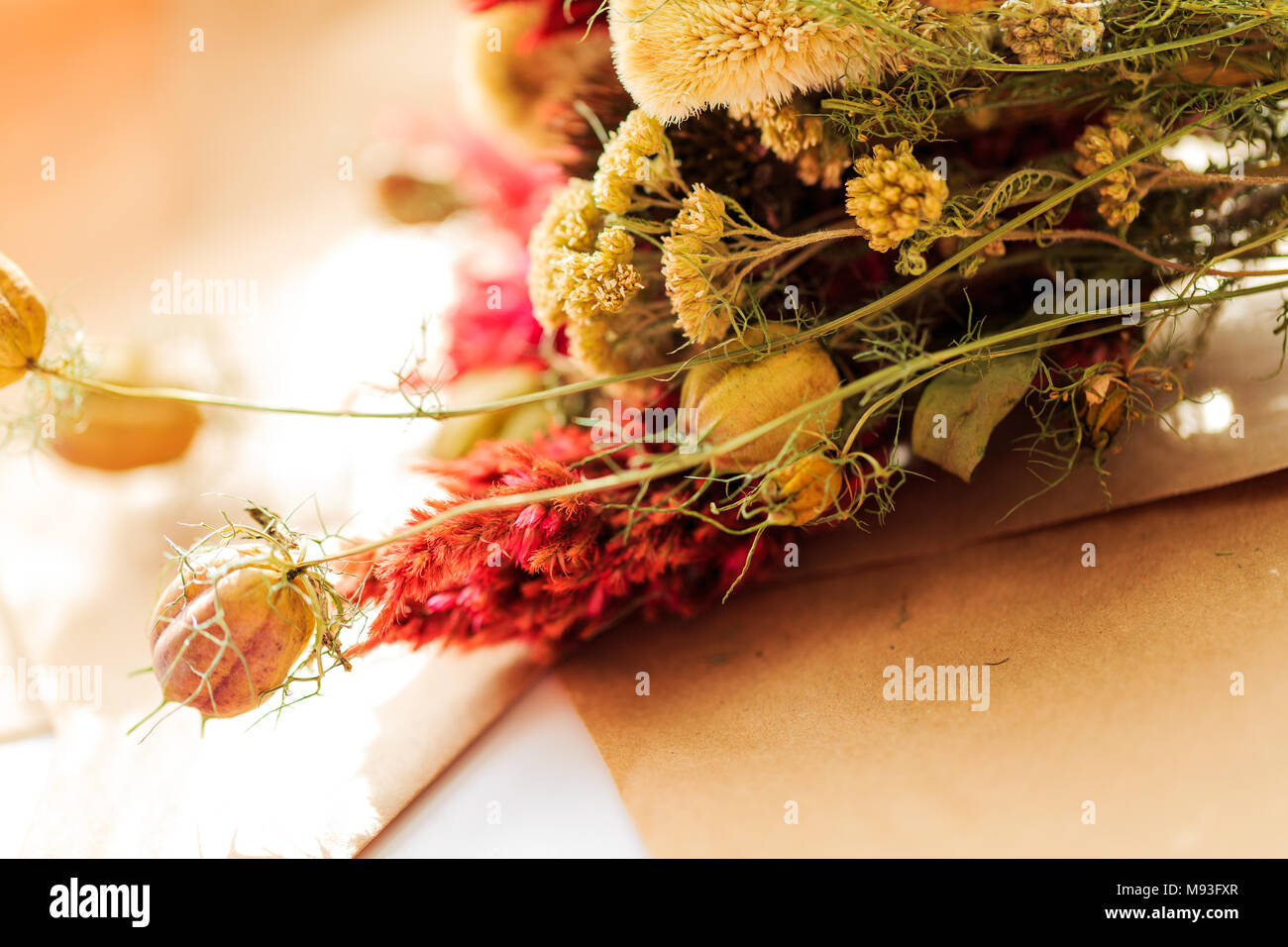 Organic dried flower arrangement set in natural light with red, yellow