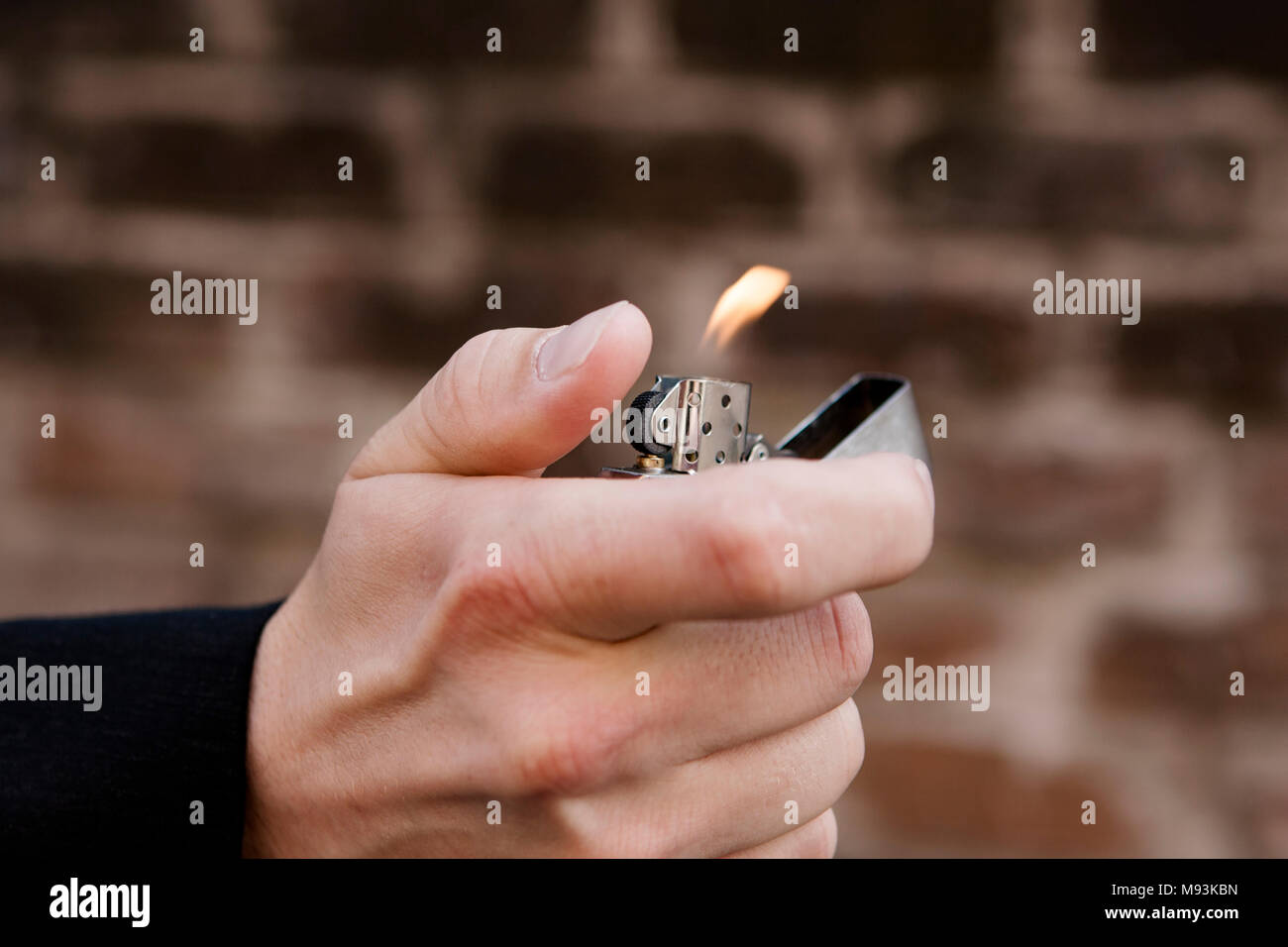 Man's hand holding a cigarette lighter Stock Photo - Alamy