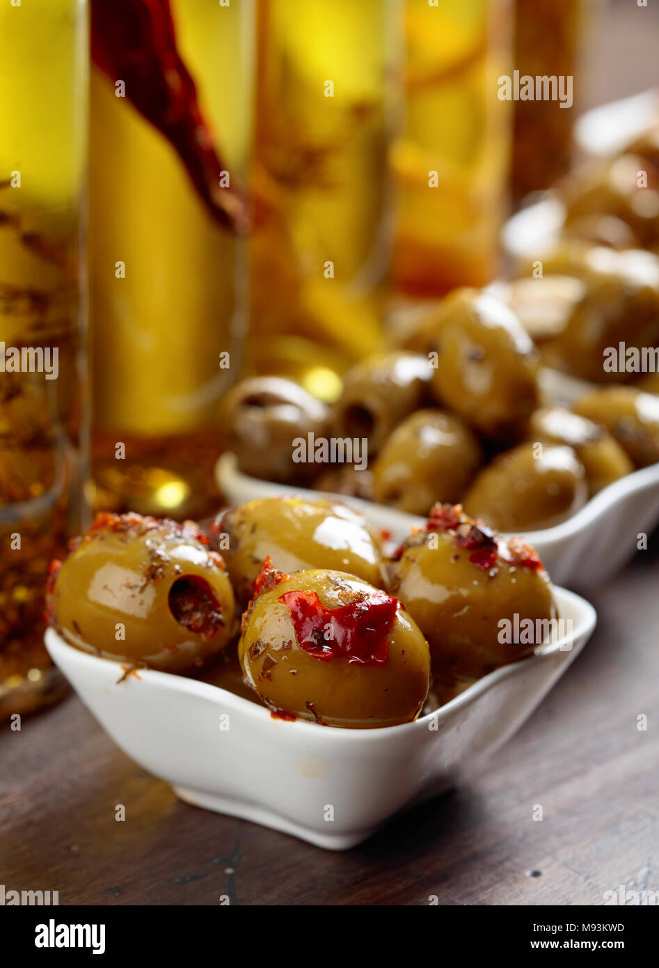 Spiced green olives and bottles with olive oil on a wooden table Stock ...