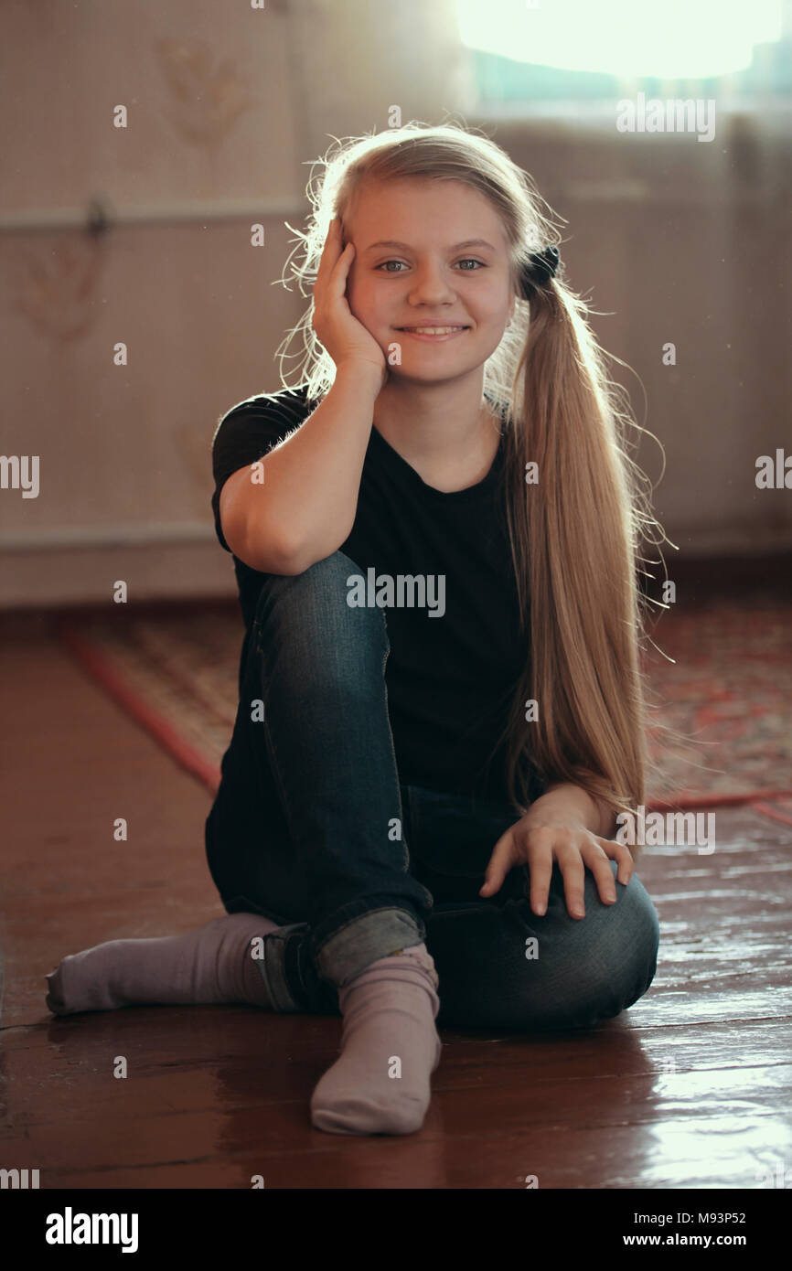Cute blonde girl teenager posing sittng on the floor Stock Photo - Alamy