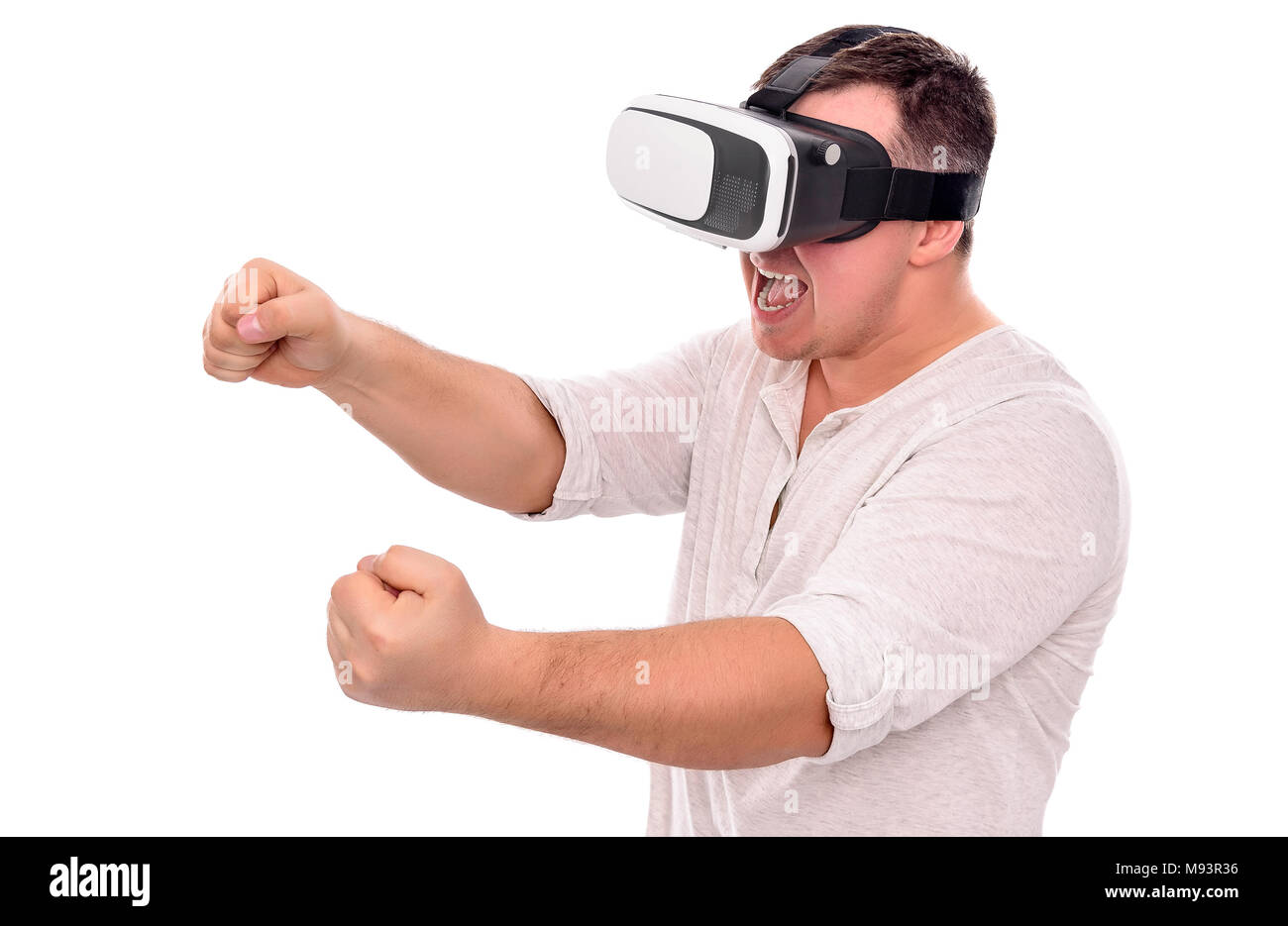 A man in virtual reality glasses is driving an invisible car playing a game or a simulator. Stock Photo