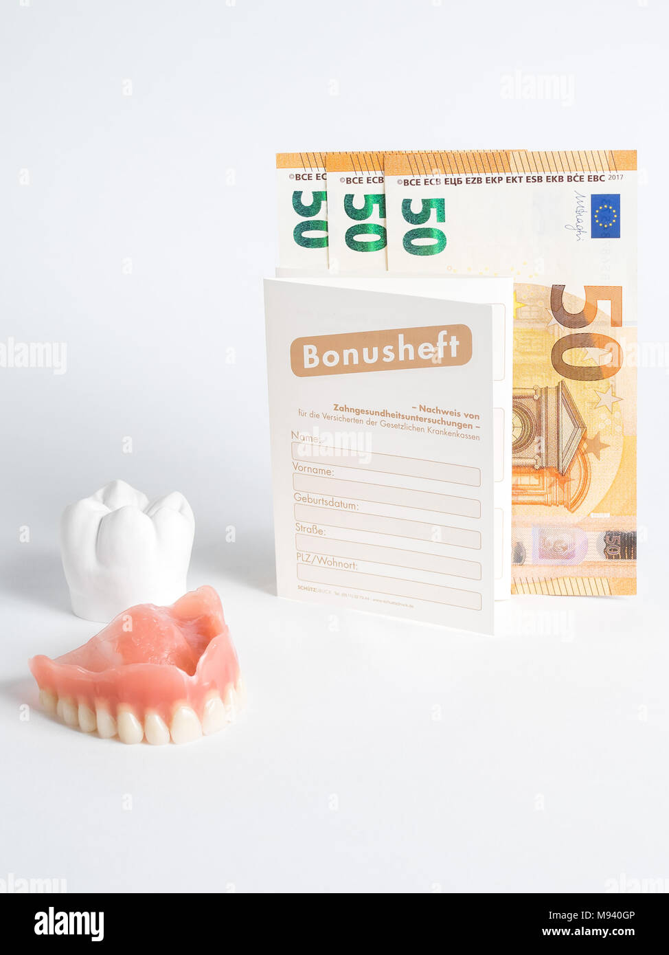 the bonus booklet of fifty euros seems to be a prosthesis and a plaster tooth Stock Photo