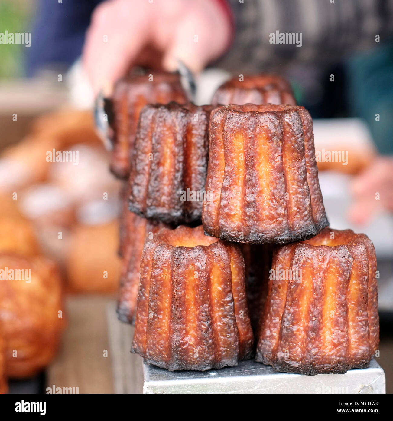 Caneles de Bordeaux made by Farro Bakery, on sale at the farmers market on Whiteladies Road, Bristol, UK Stock Photo