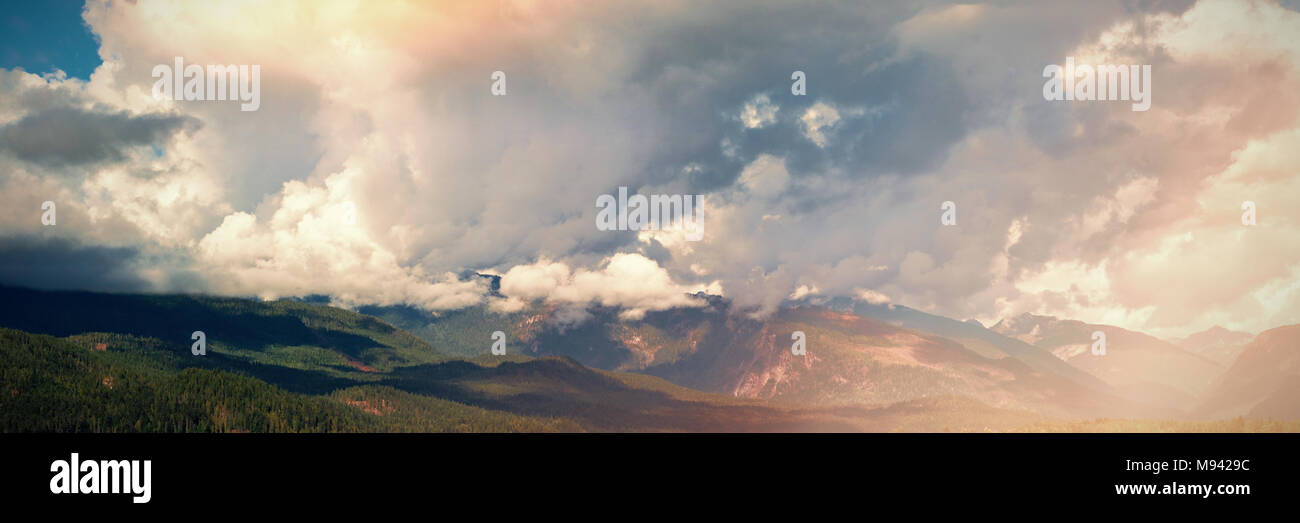 Cloudy sky over green mountains and river Stock Photo - Alamy