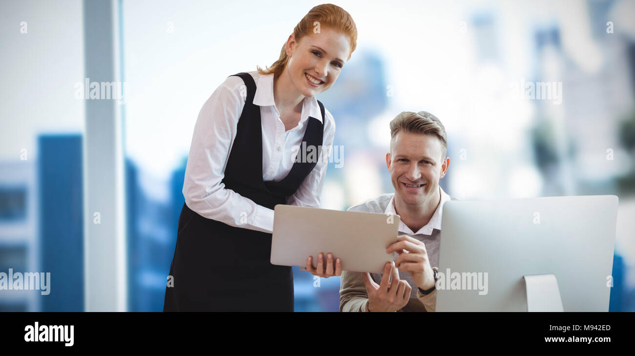 Composite image of portrait of smiling colleagues at table Stock Photo