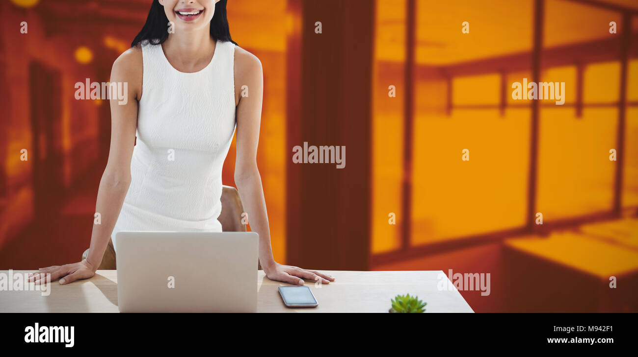 Composite image of portrait of businesswoman with laptop standing at table Stock Photo