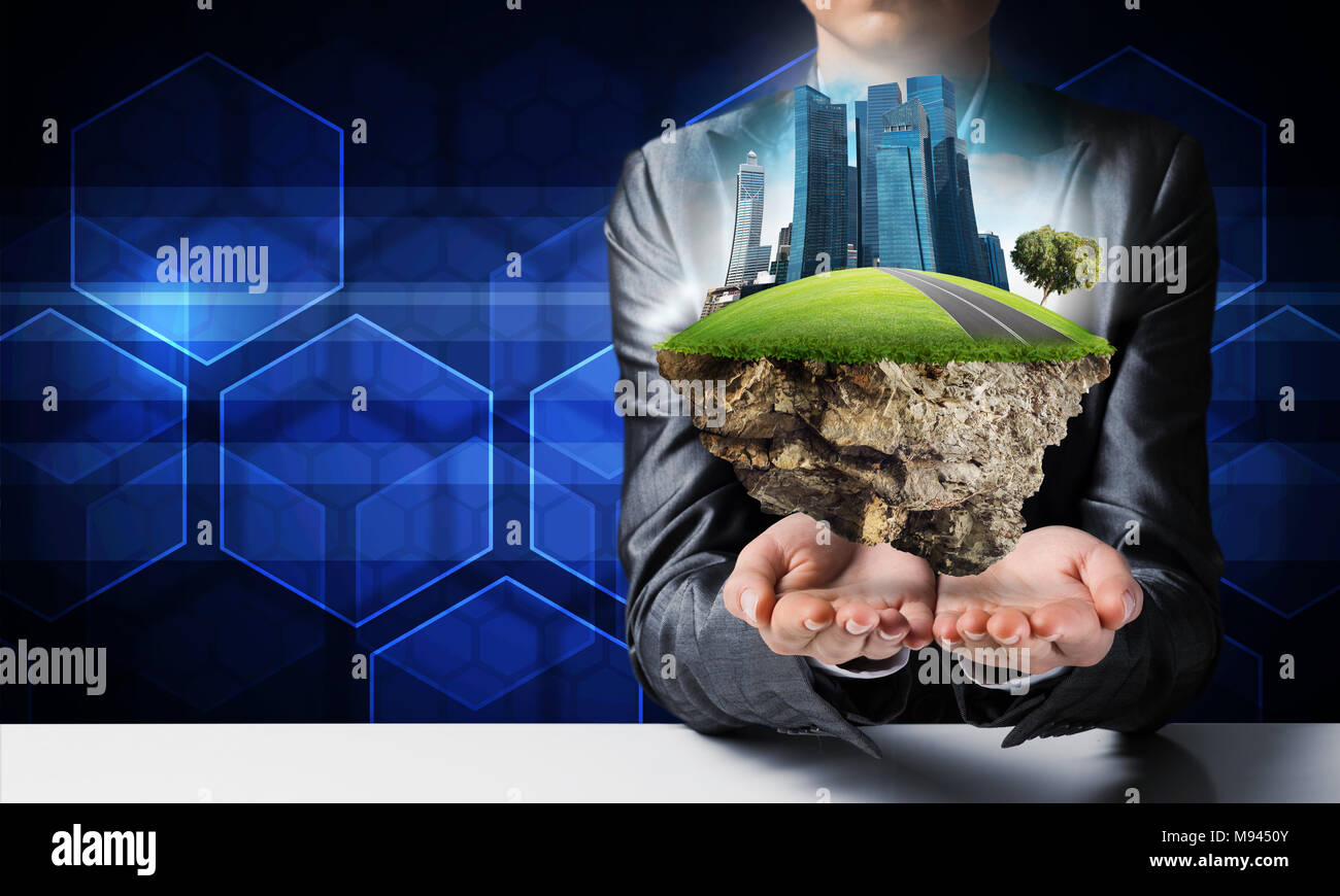 Businessman in suit keeping green island with skycraper city in hands with media icons on background. Stock Photo