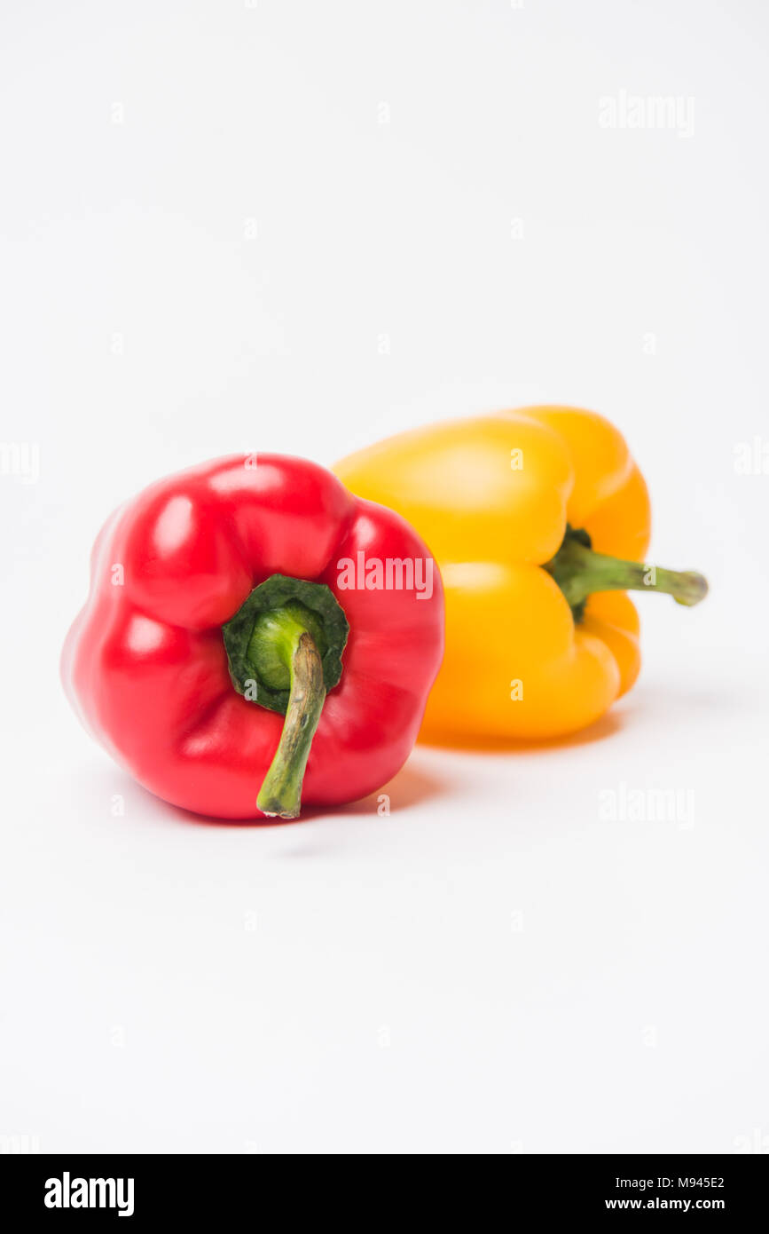 red and yellow bell peppers laying on white background Stock Photo - Alamy