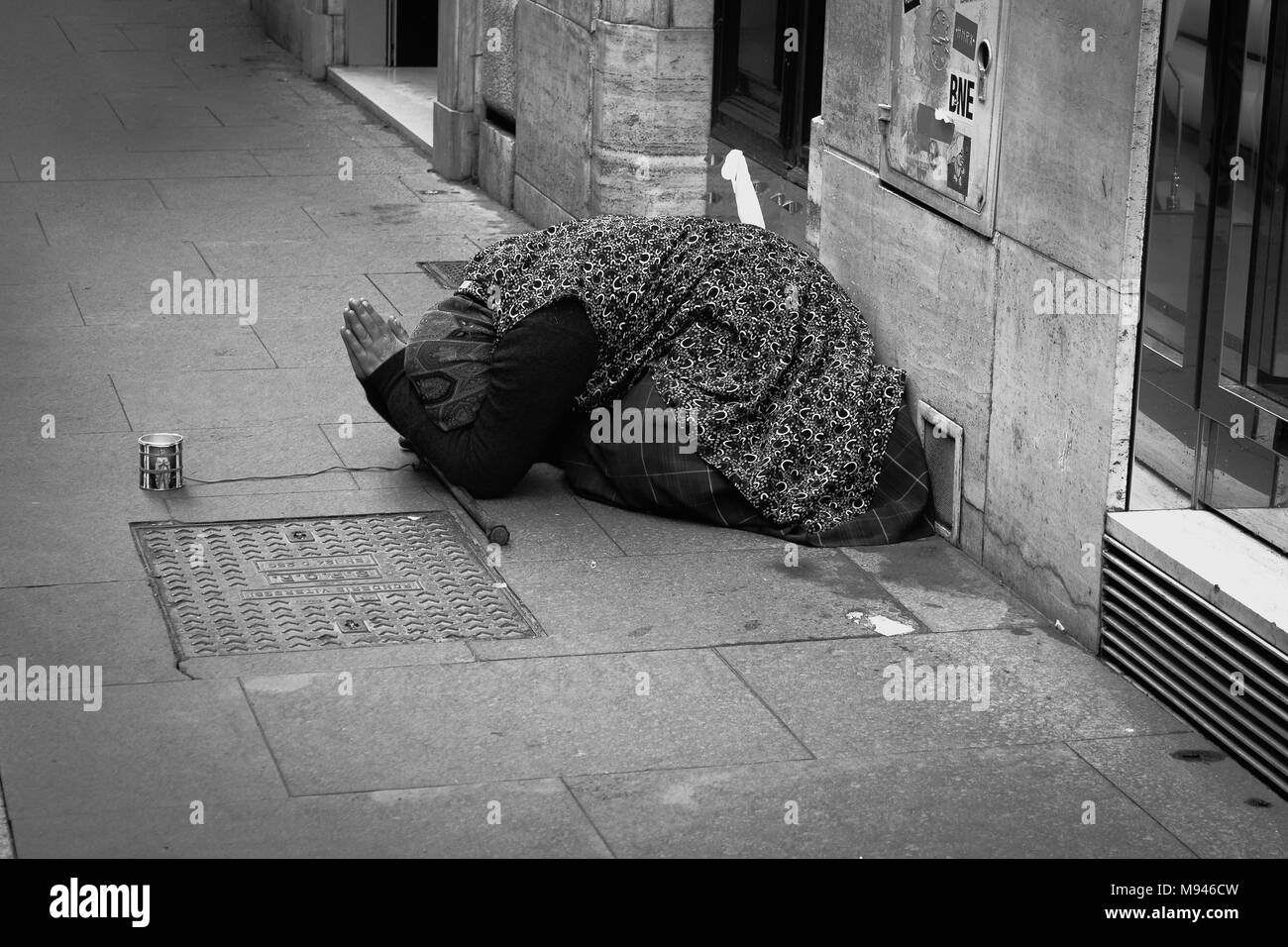 An old lady praying and begging for money on the street Stock Photo