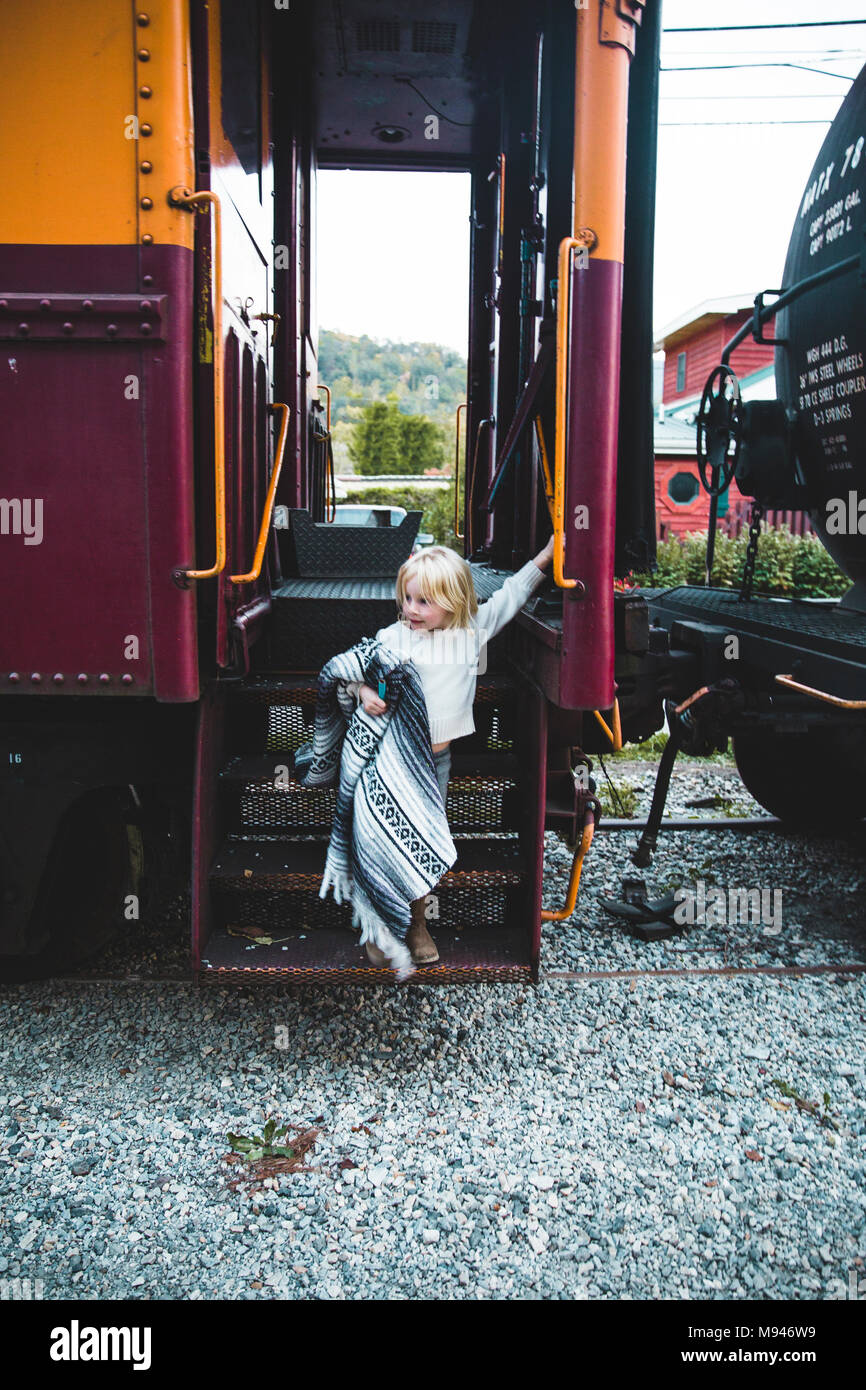 Girl with blanket coming out of train Stock Photo Alamy