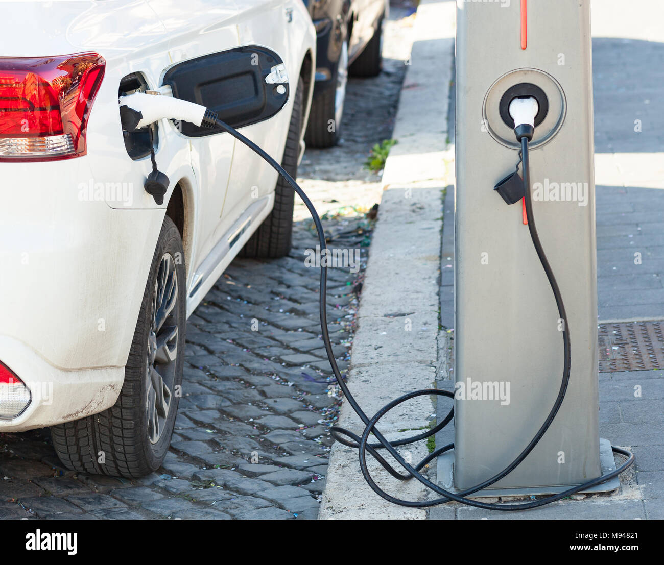 The electric car charger plugged in to the socket.The modern electric car charging the battery. Stock Photo