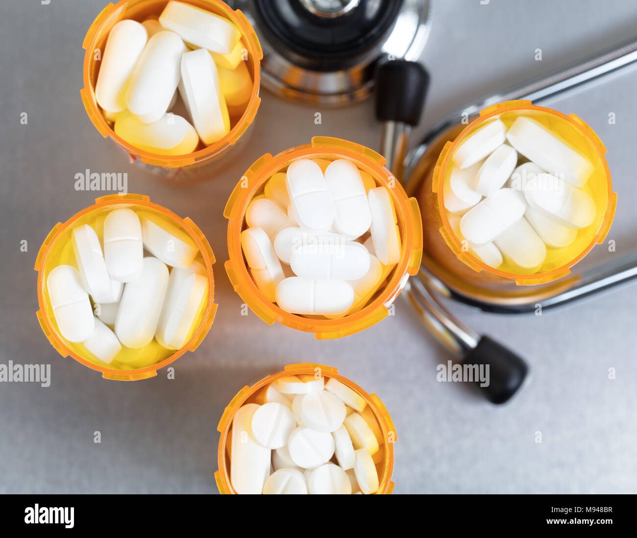 Close up overhead view of full prescription bottles with stethoscope on stainless steel background Stock Photo