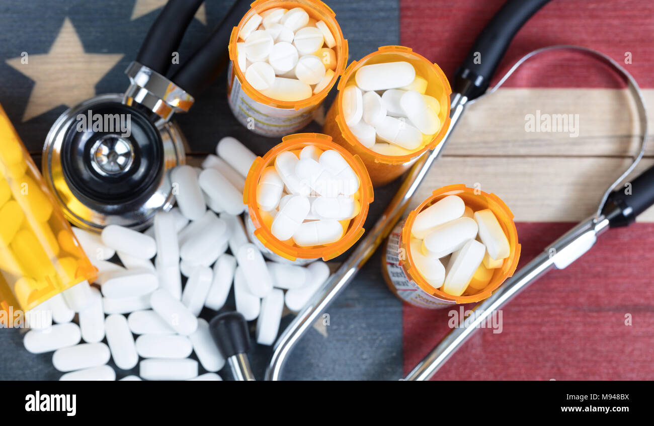 Top view of full prescription bottles with stethoscope and pills on rustic wooden United States background Stock Photo