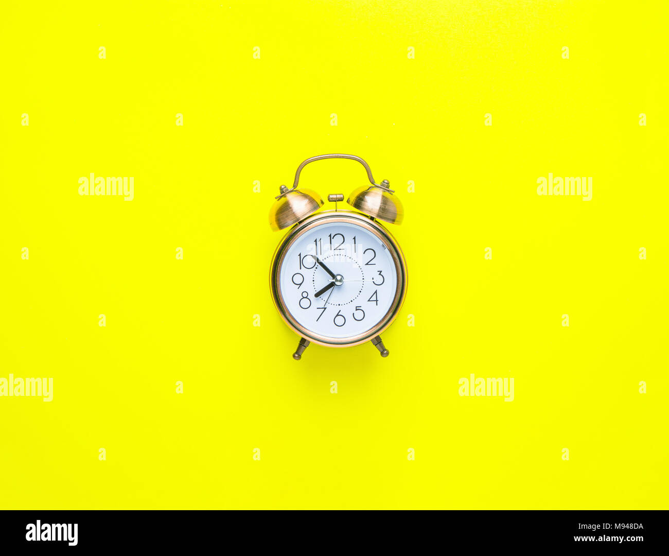 Alarm Clock Showing Eight O'Clock on Bright Yellow Background. Flat Lay