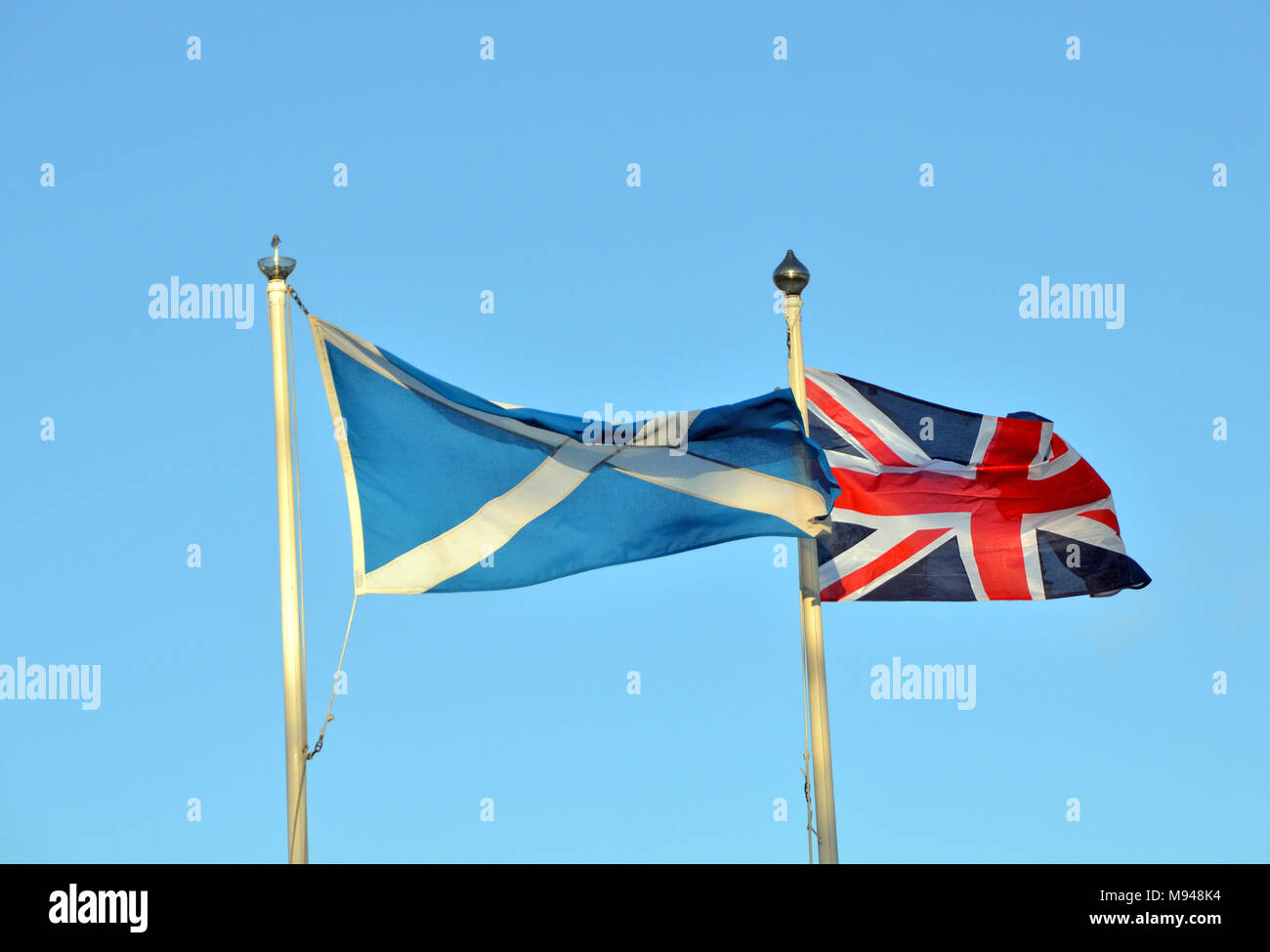 the Scottish Saltire and Union Jack flags fly next to each other. Stock Photo