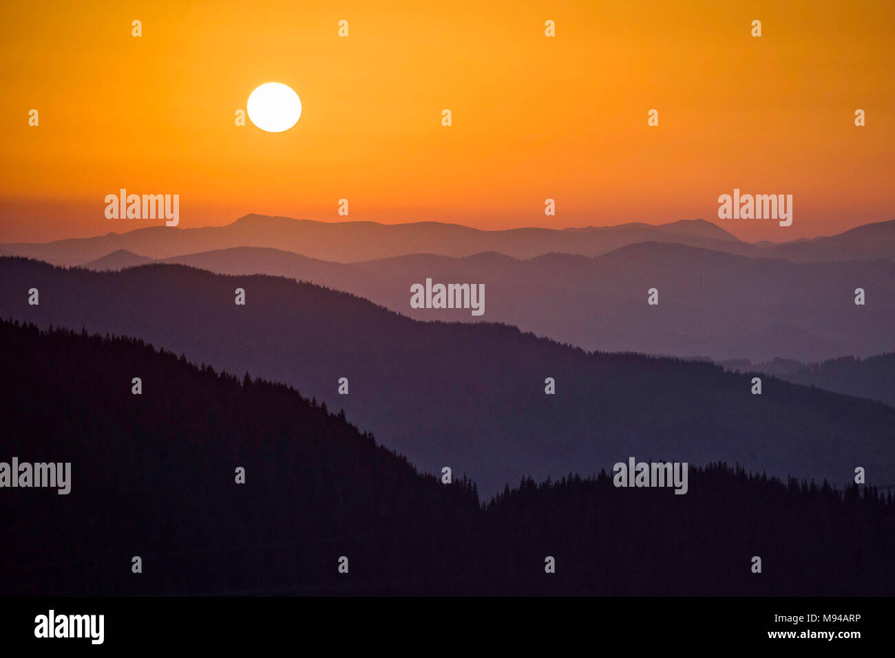 Sunset over the hills and mountains of Bucovina region in Romania Stock Photo
