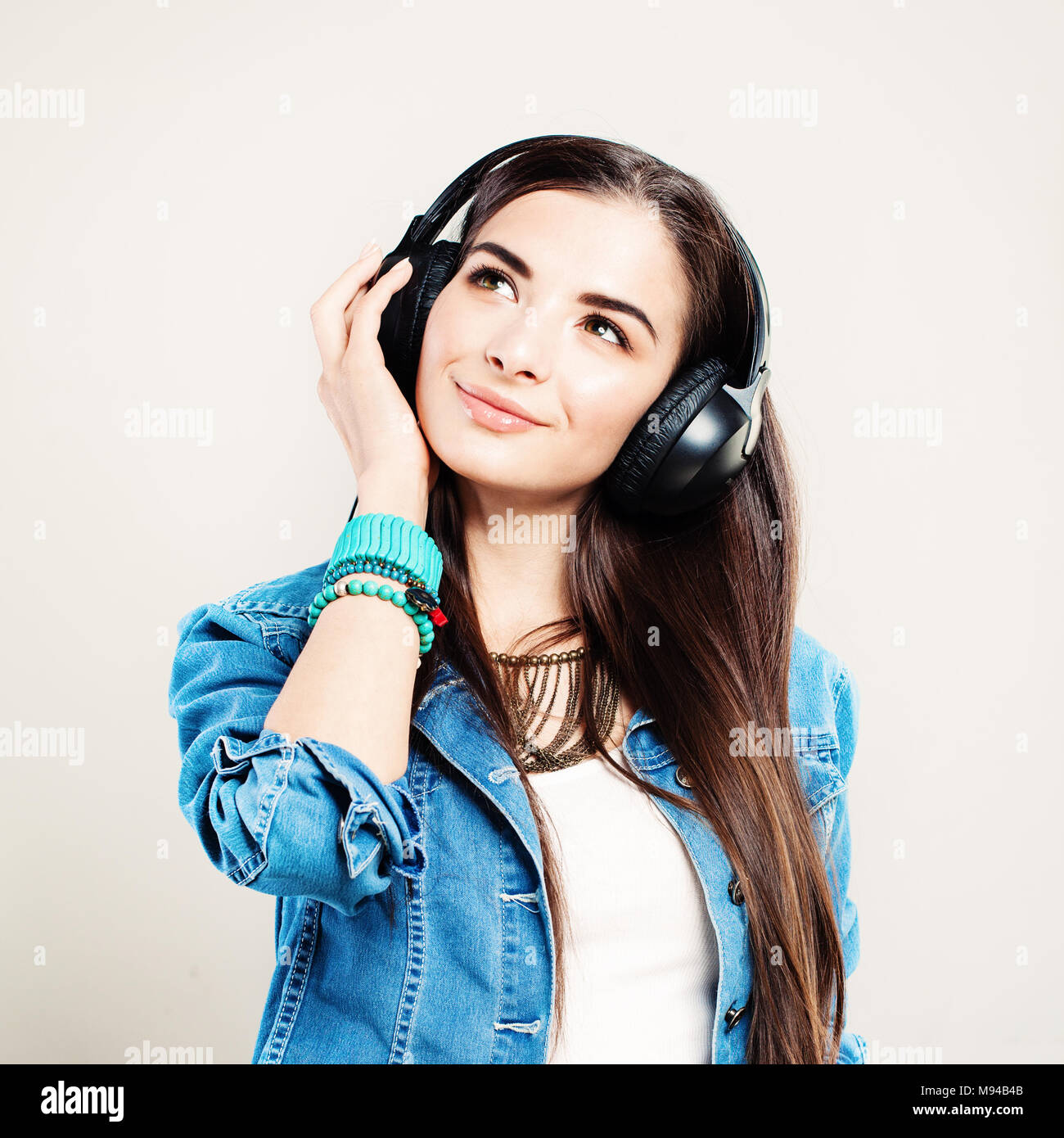 Happy Girl Enjoying the Music and Looking Up. Young Beautiful Woman with Earphones Stock Photo
