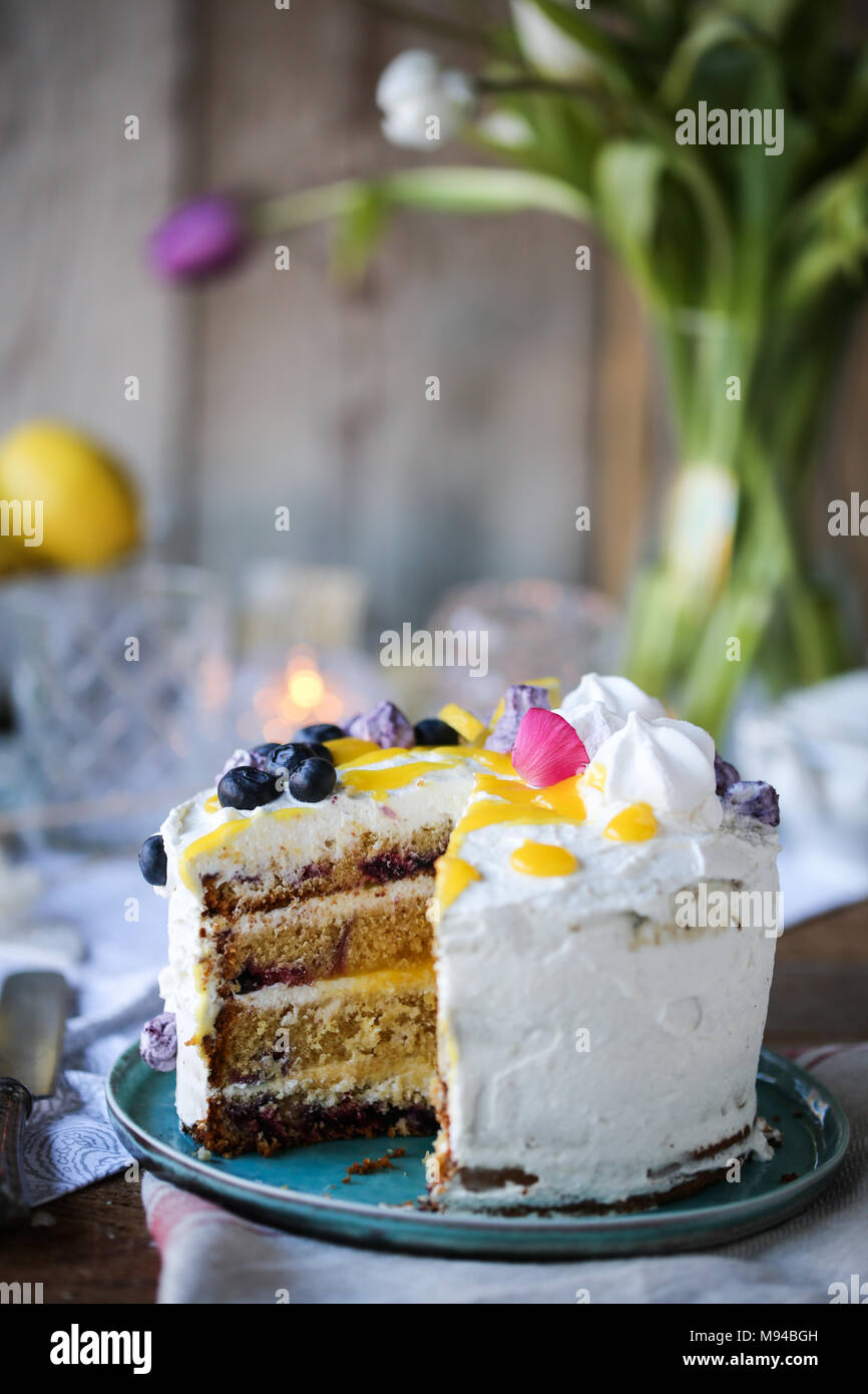 Blueberry and lemon curd layered cake with meringues. Stock Photo