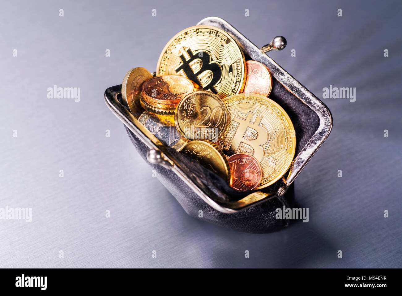 Wallet filled with two Bitcoin and many Euro coins Stock Photo