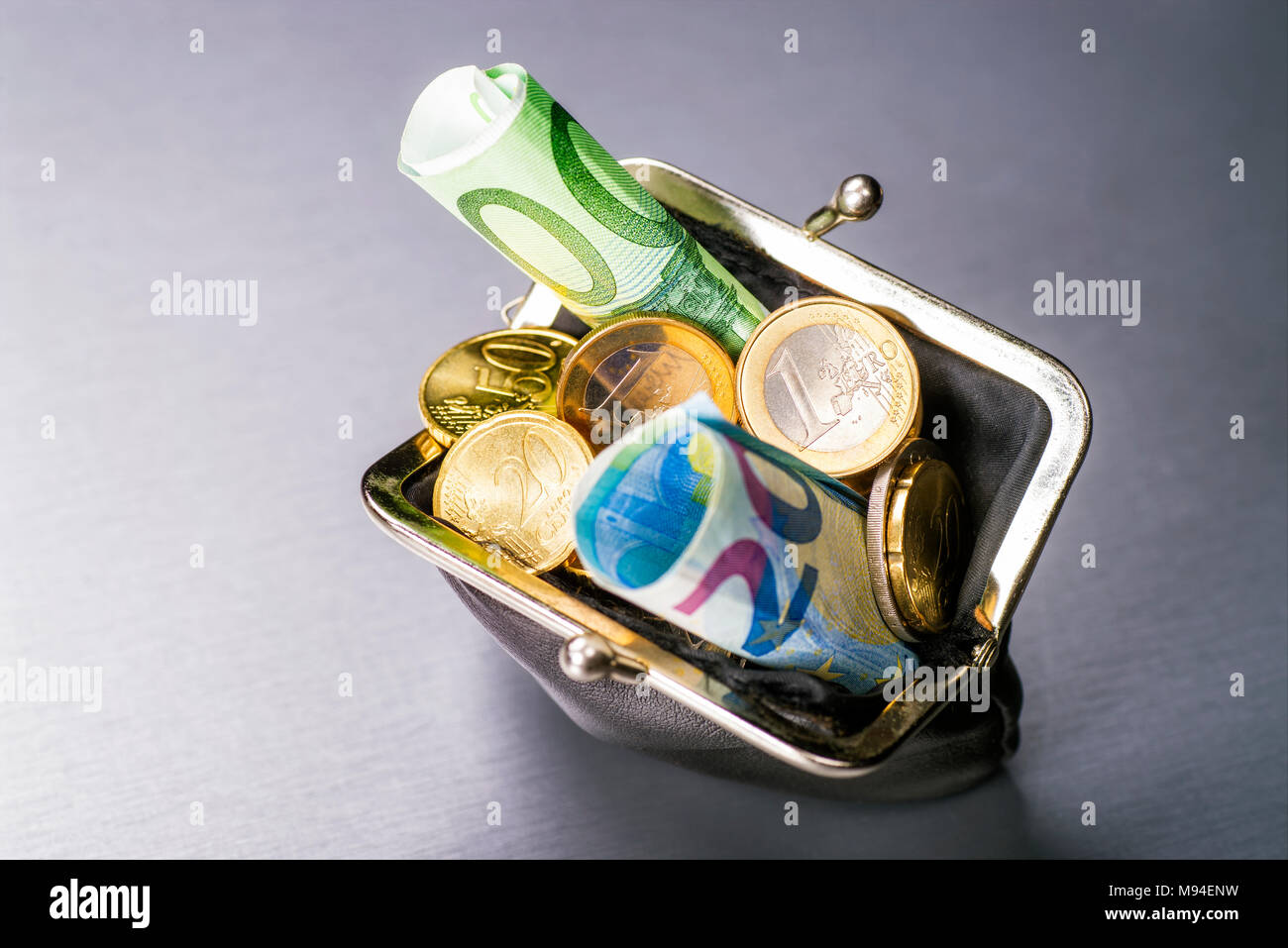 Wallet filled with many euro coins and banknotes Stock Photo