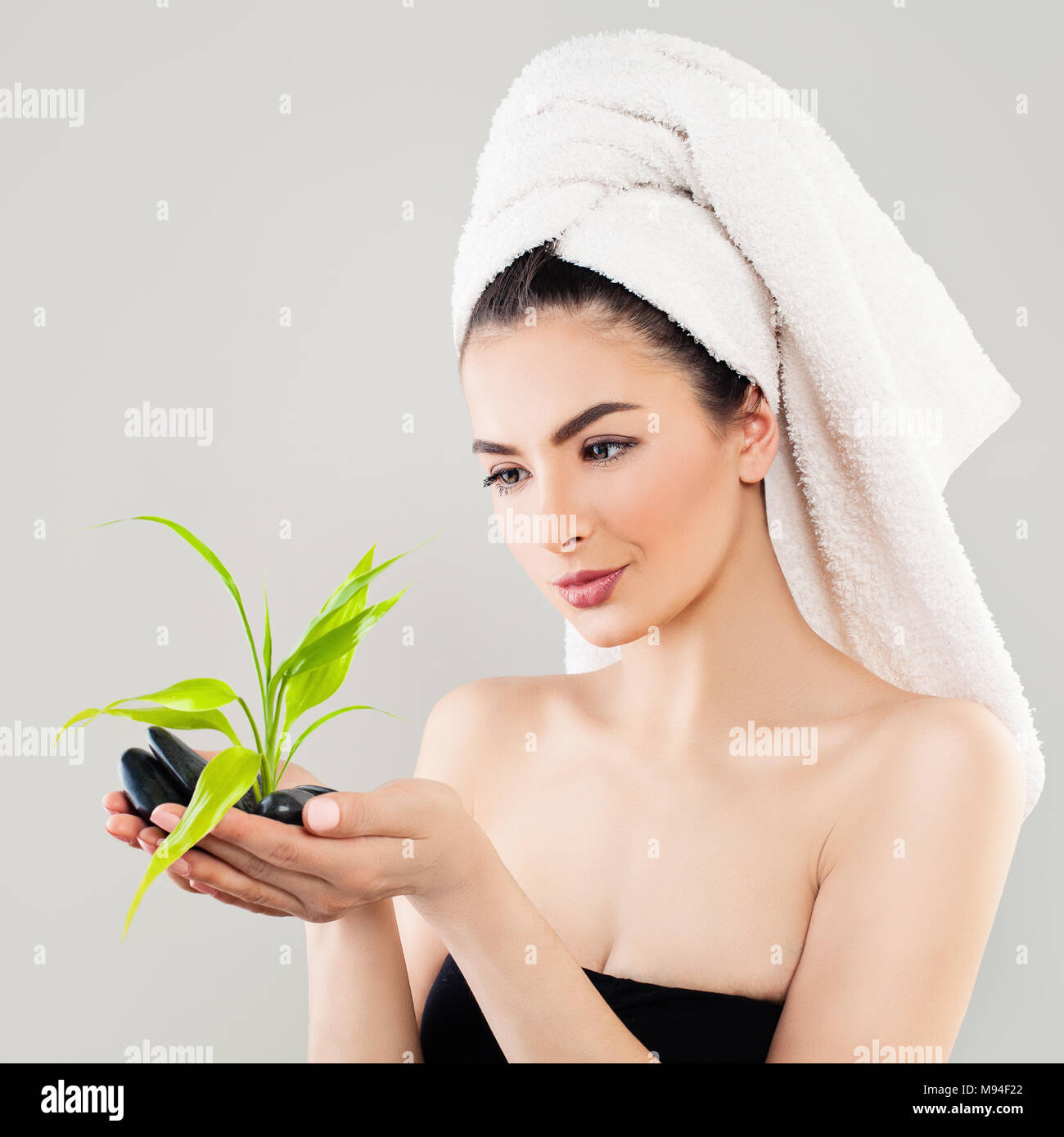 Spa Portrait of Healthy Woman with Black Stones and Green Bamboo
