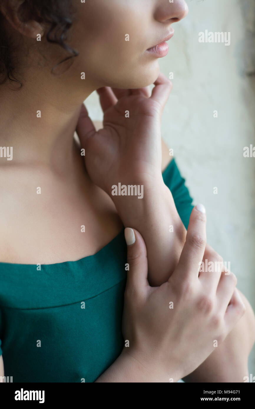 Close up of a young woman hands touching neck Stock Photo - Alamy