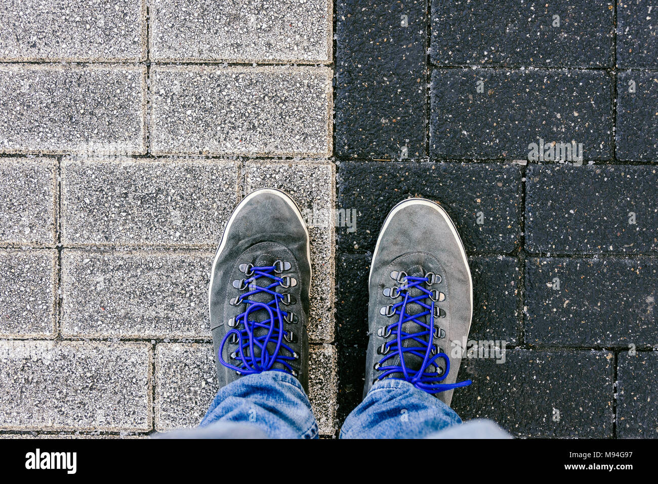 Reaching a crossroads having to decide about past, now and future  symbolized by two feet and shoes standing on two different colors on  pathway from ab Stock Photo - Alamy