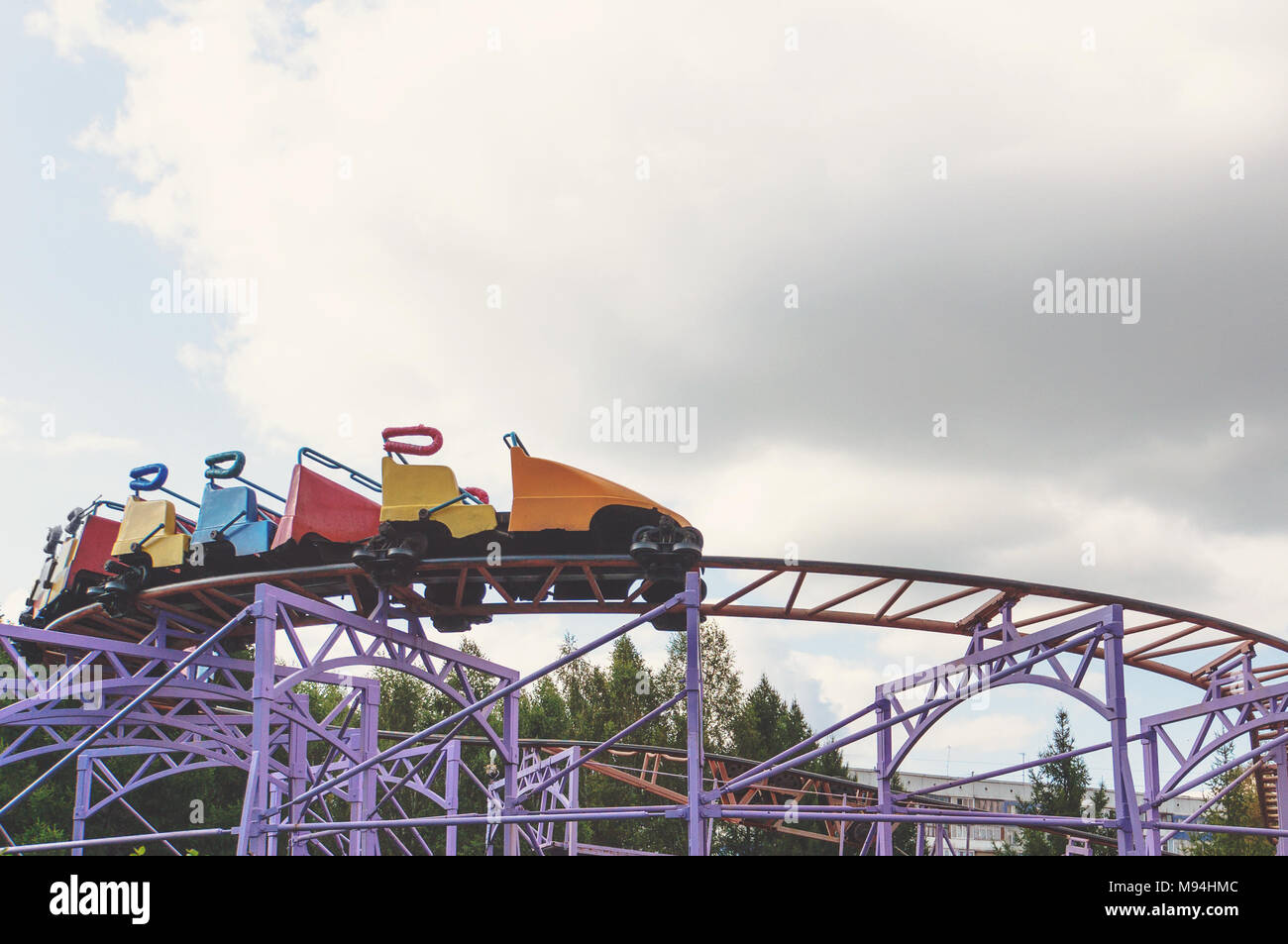 A roller coaster ride on the background of white sky. Toned retro photo. Stock Photo