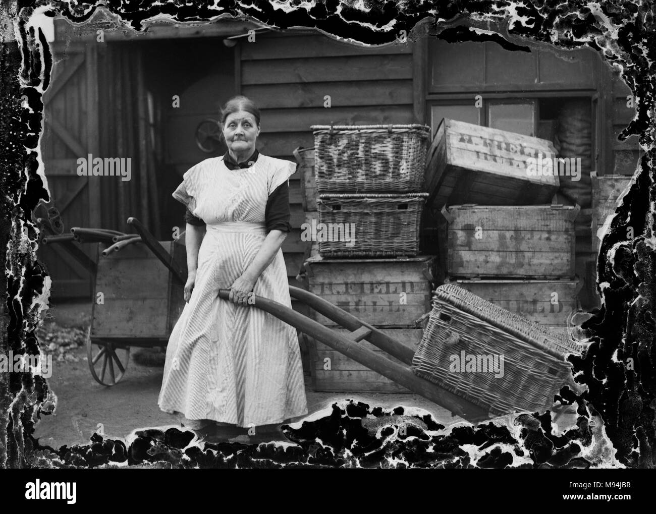 Working woman on the streets of London is shown in a vintage glass negative with damage on the edge framing the subject, ca. 1910. Stock Photo