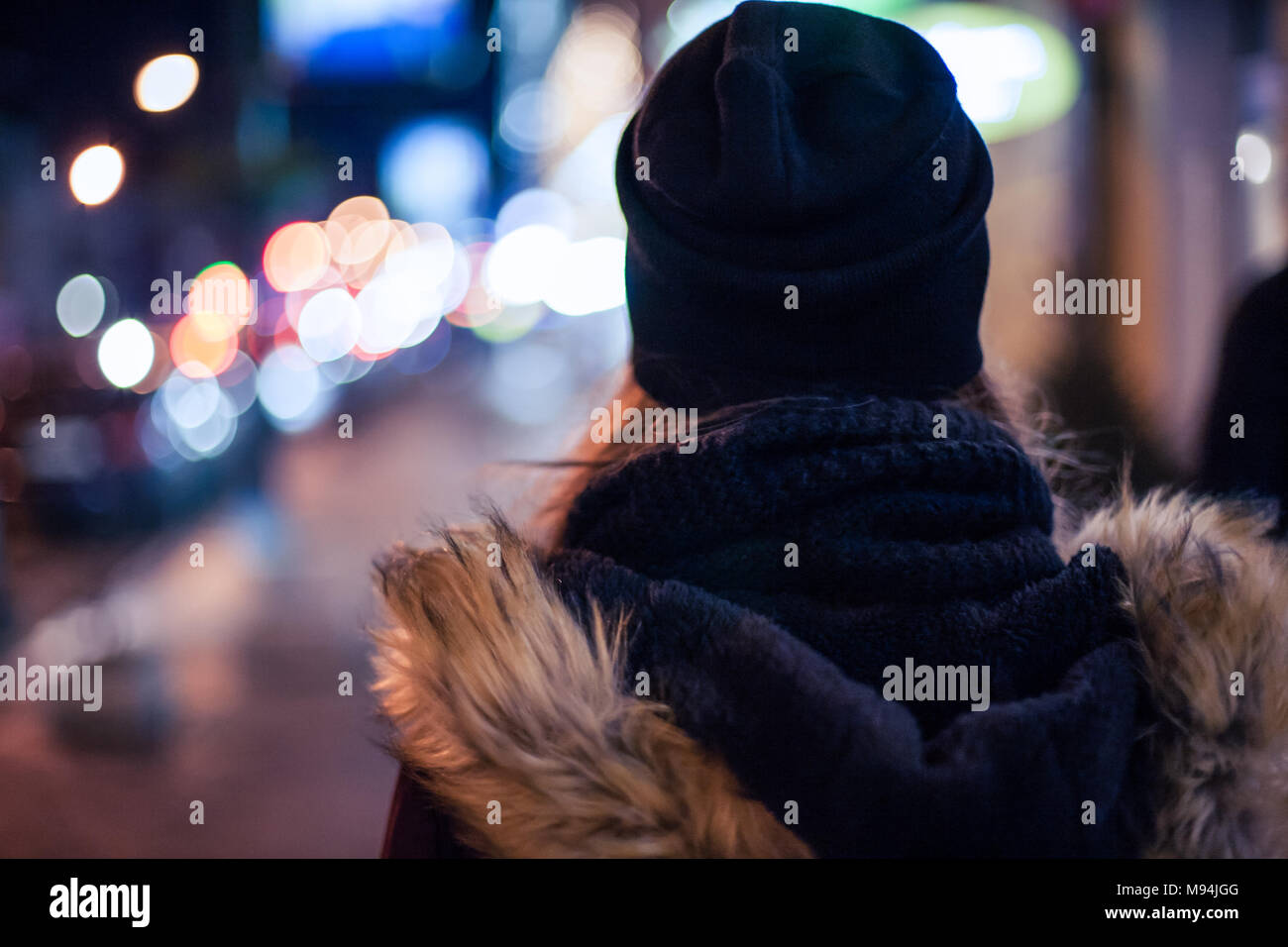 Back view of a hipster girl walking on city street at night Stock Photo ...