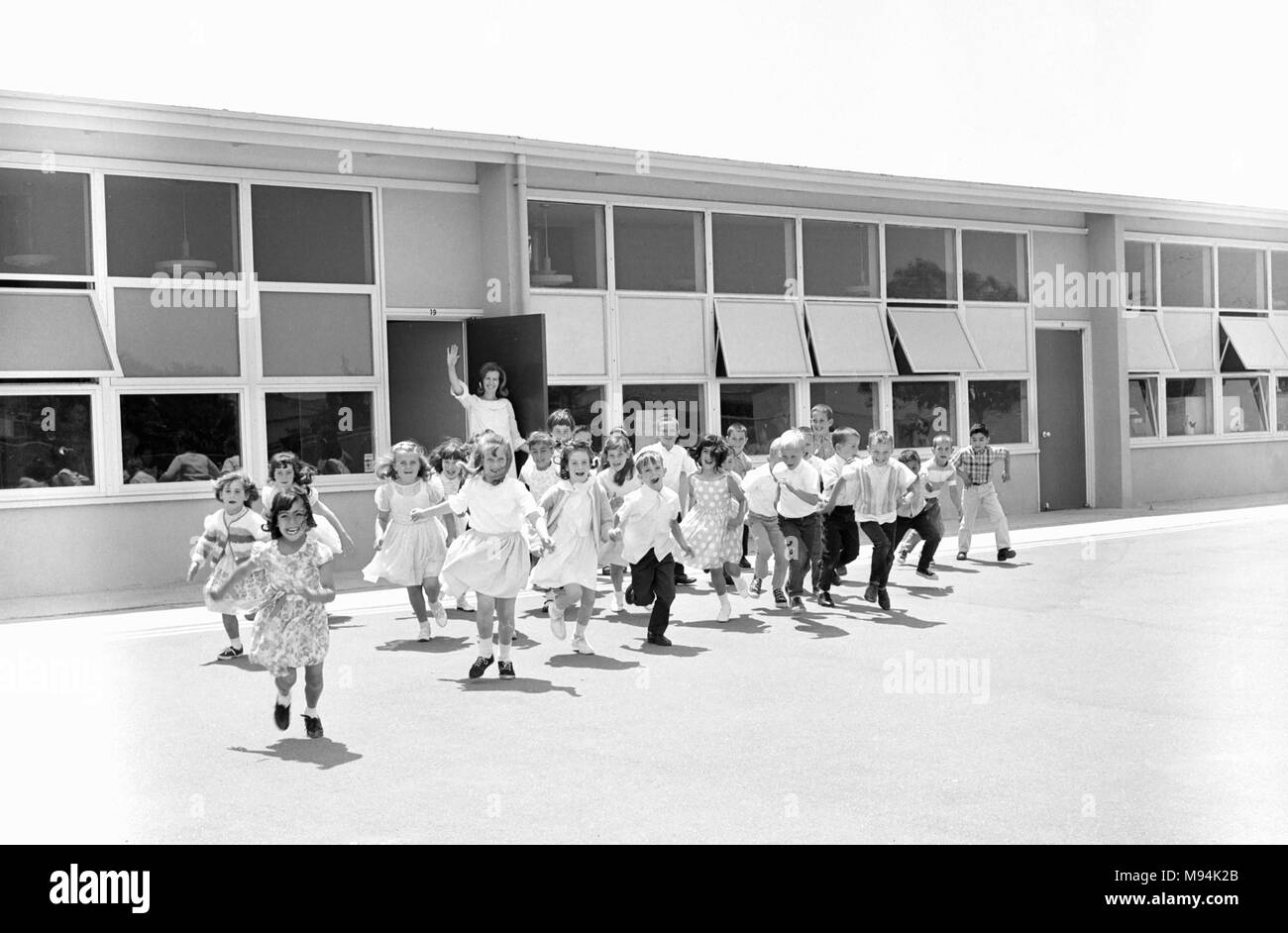 Elementary students head out the school door and class in California, ca. 1965. Stock Photo
