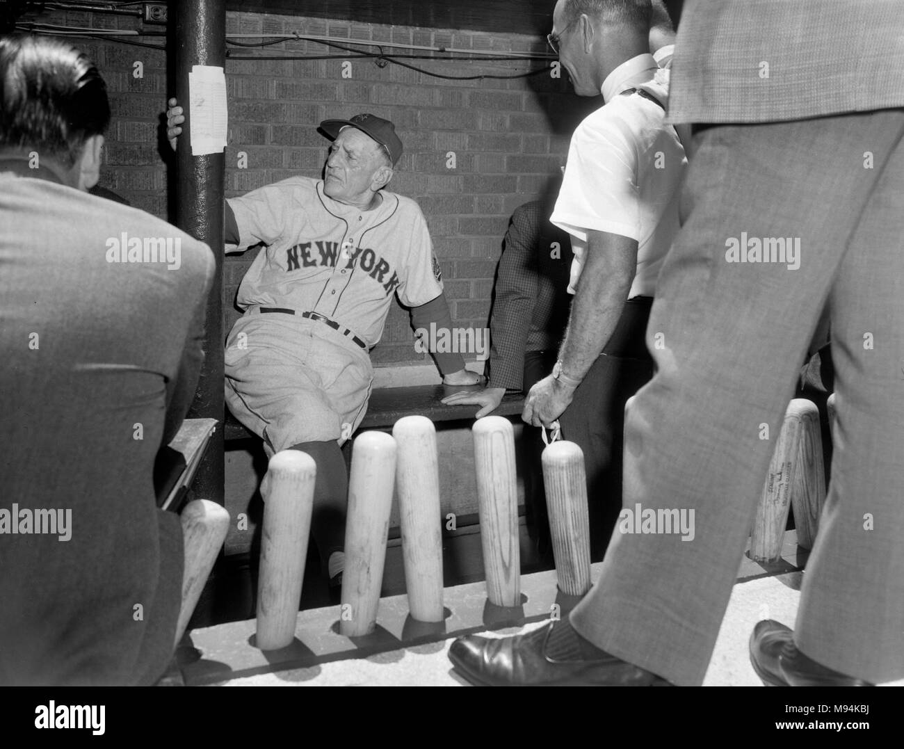 New York Mets manager Casey Stengel talks to reporters from his dugout perch at Wrigley Field in Chicago in 1963. Stock Photo