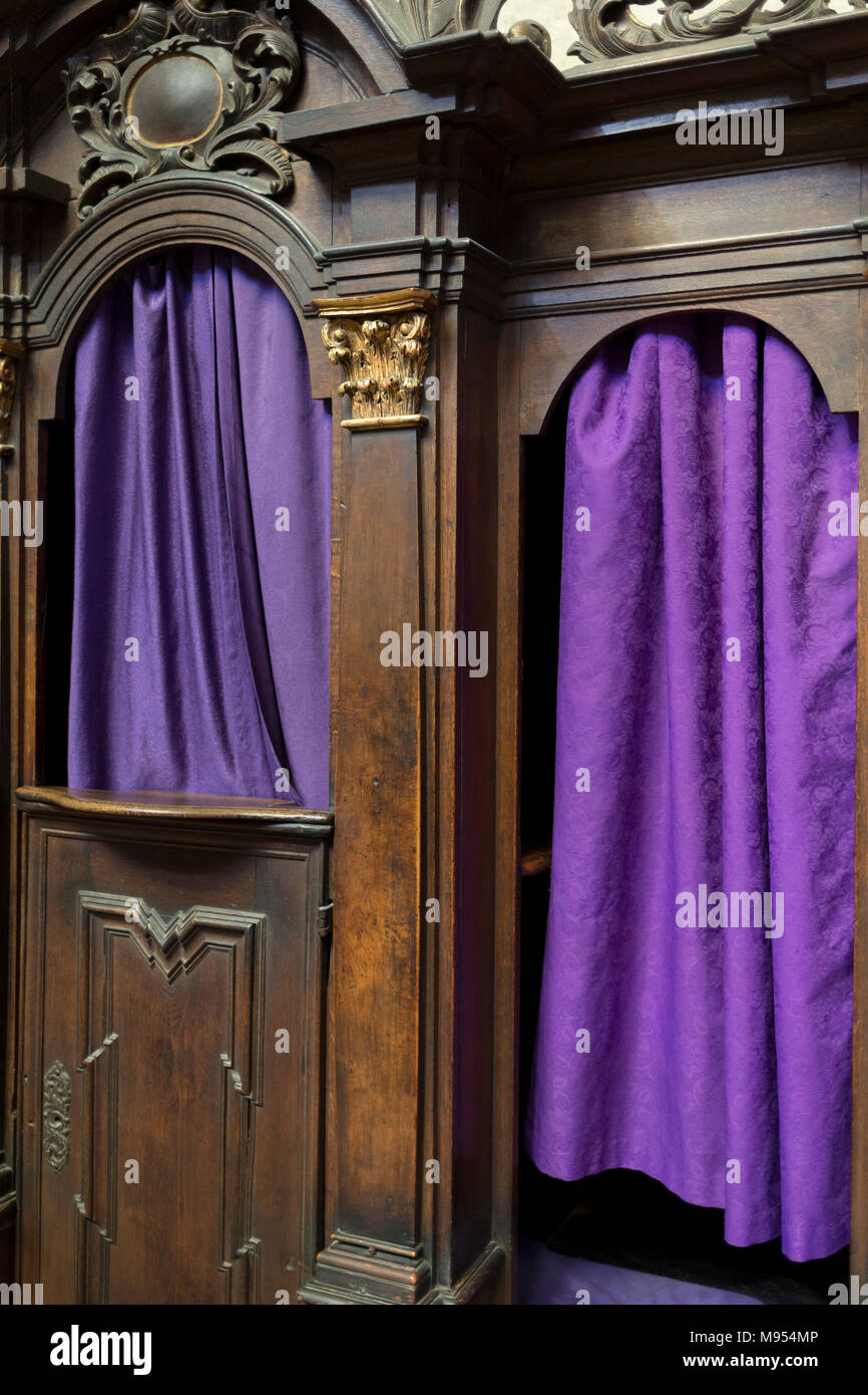 Purple Catholic confessional curtains in St Vitas' Cathedral in Prague Castle, on 18th March, 2018, in Prague, the Czech Republic. The Metropolitan Cathedral of Saints Vitus, Wenceslaus and Adalbert is a Roman Catholic metropolitan cathedral in Prague, the seat of the Archbishop of Prague. Until 1997, the cathedral was dedicated only to Saint Vitus, and is still commonly named only as St. Vitus Cathedral. This cathedral is a prominent example of Gothic architecture and is the largest and most important church in the country. It is located within Hradcany-Prazsky Hrad (Prague Castle) in the Cze Stock Photo