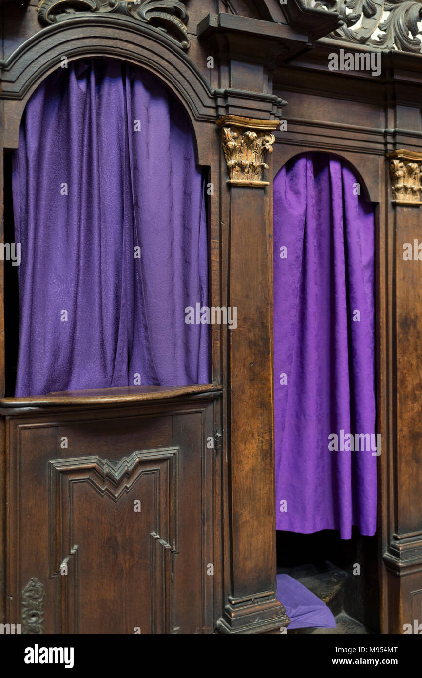 Purple Catholic confessional curtains in St Vitas' Cathedral in Prague Castle, on 18th March, 2018, in Prague, the Czech Republic. The Metropolitan Cathedral of Saints Vitus, Wenceslaus and Adalbert is a Roman Catholic metropolitan cathedral in Prague, the seat of the Archbishop of Prague. Until 1997, the cathedral was dedicated only to Saint Vitus, and is still commonly named only as St. Vitus Cathedral. This cathedral is a prominent example of Gothic architecture and is the largest and most important church in the country. It is located within Hradcany-Prazsky Hrad (Prague Castle) in the Cze Stock Photo