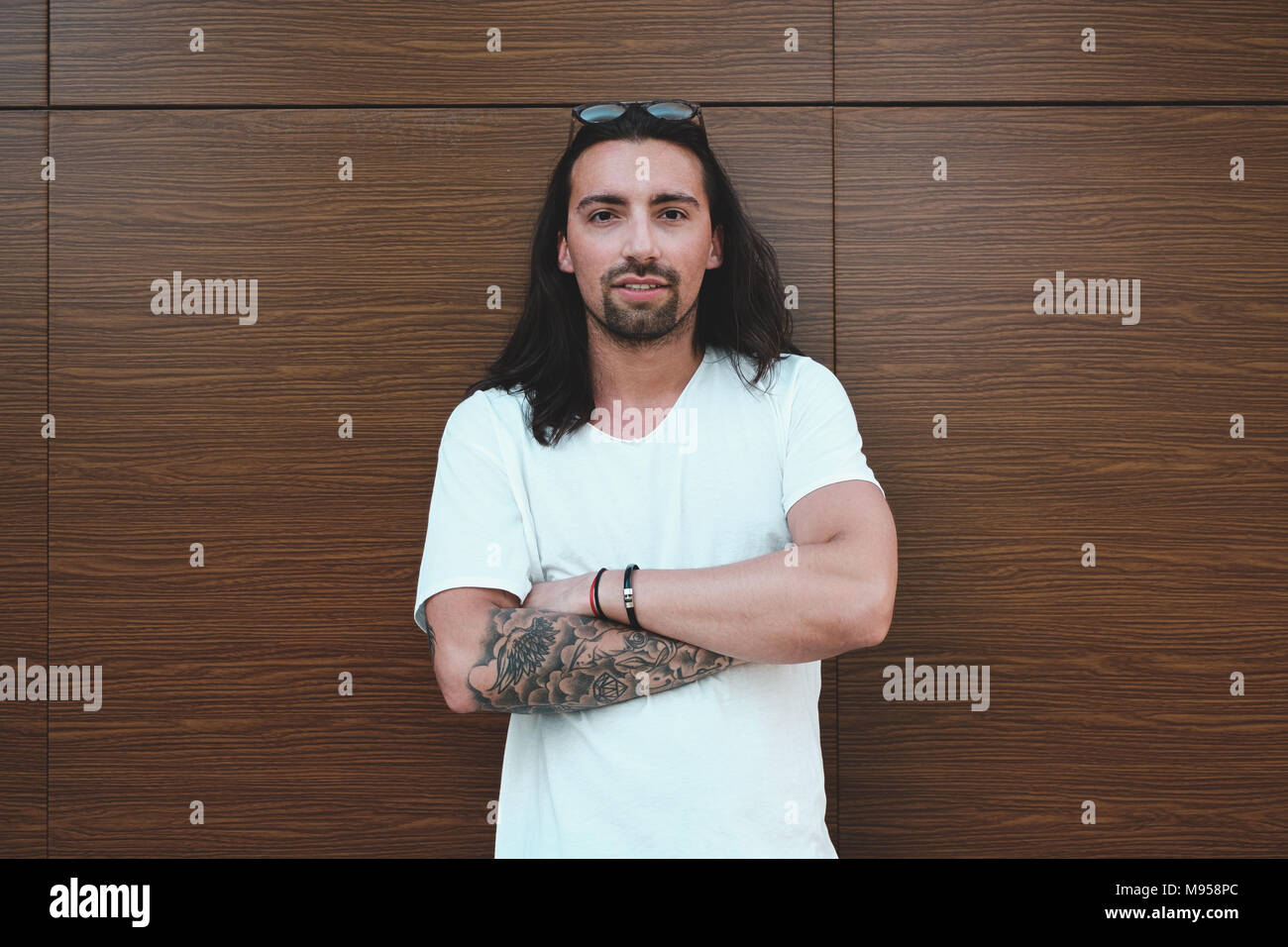 Beautiful Long Haired Man With Beard And Tattoos Posing On A Wood