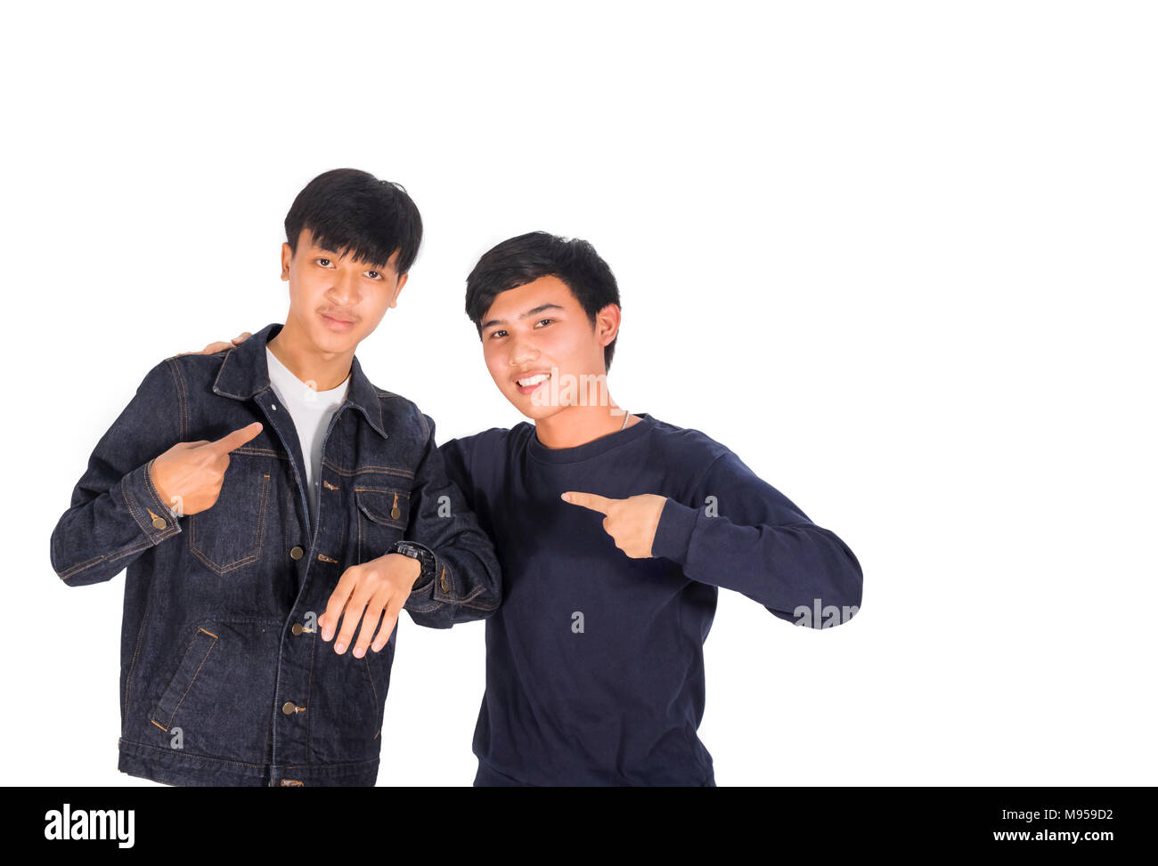 Two Asian boys are pointing to themselves white background. Stock Photo