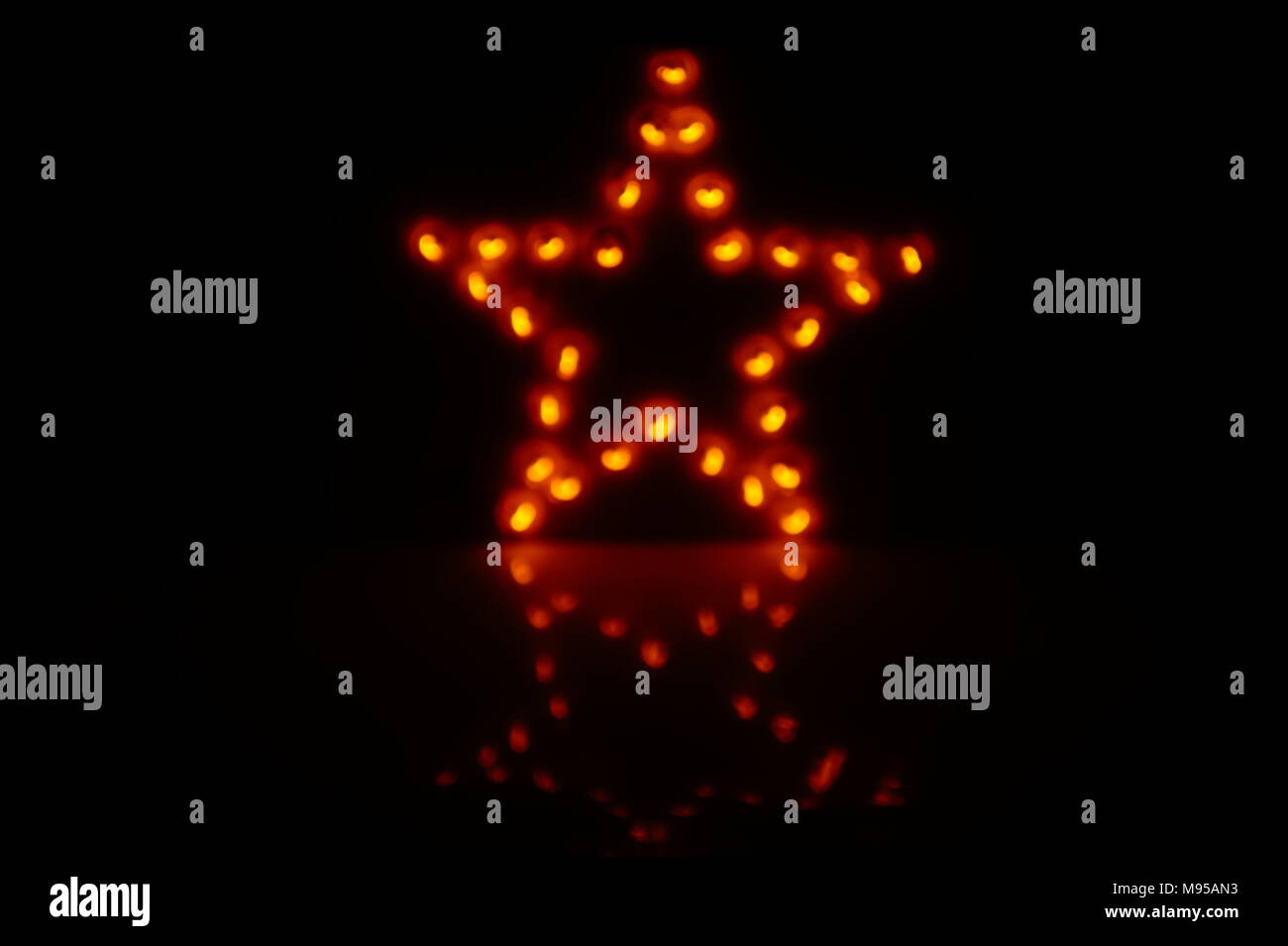 Decorative star with lamps on a black background. Stock Photo
