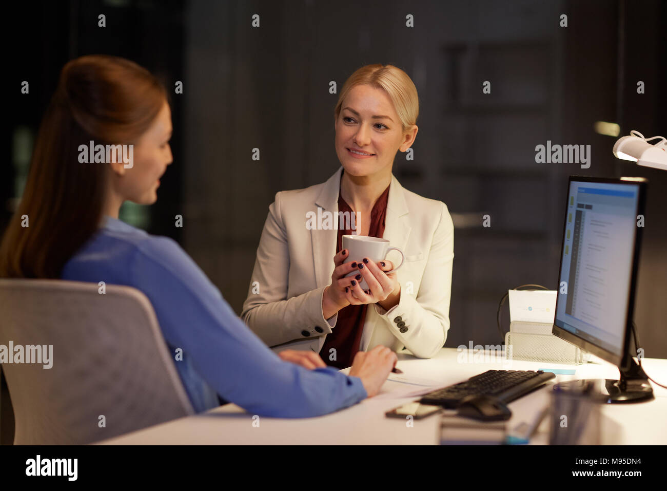 businesswomen drinking coffee at night office Stock Photo Alamy