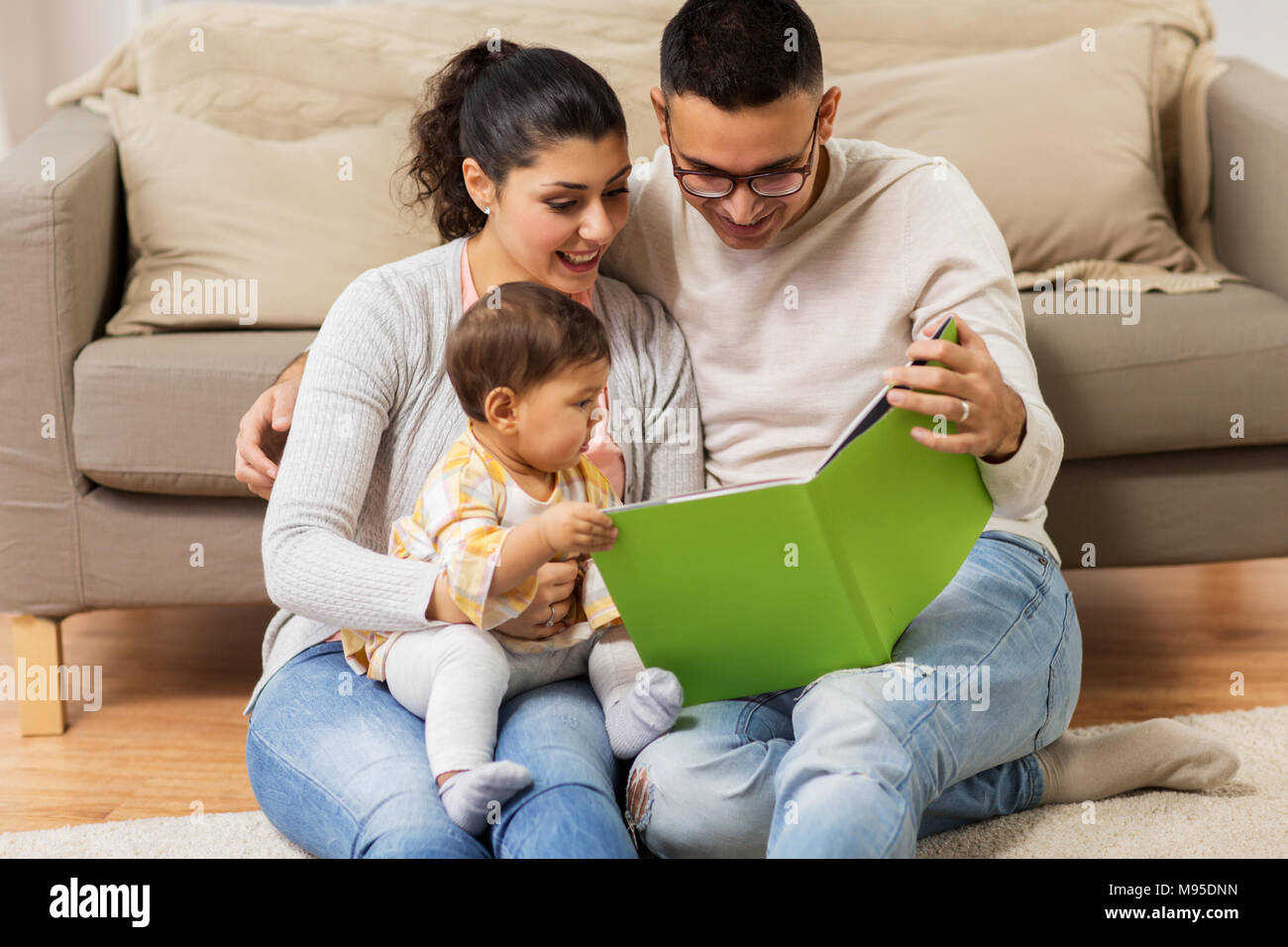 happy family with baby reading book at home Stock Photo Alamy