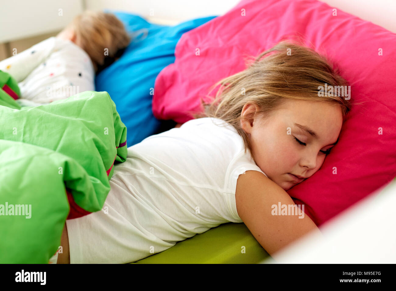 little girls sleeping in bed at home Stock Photo