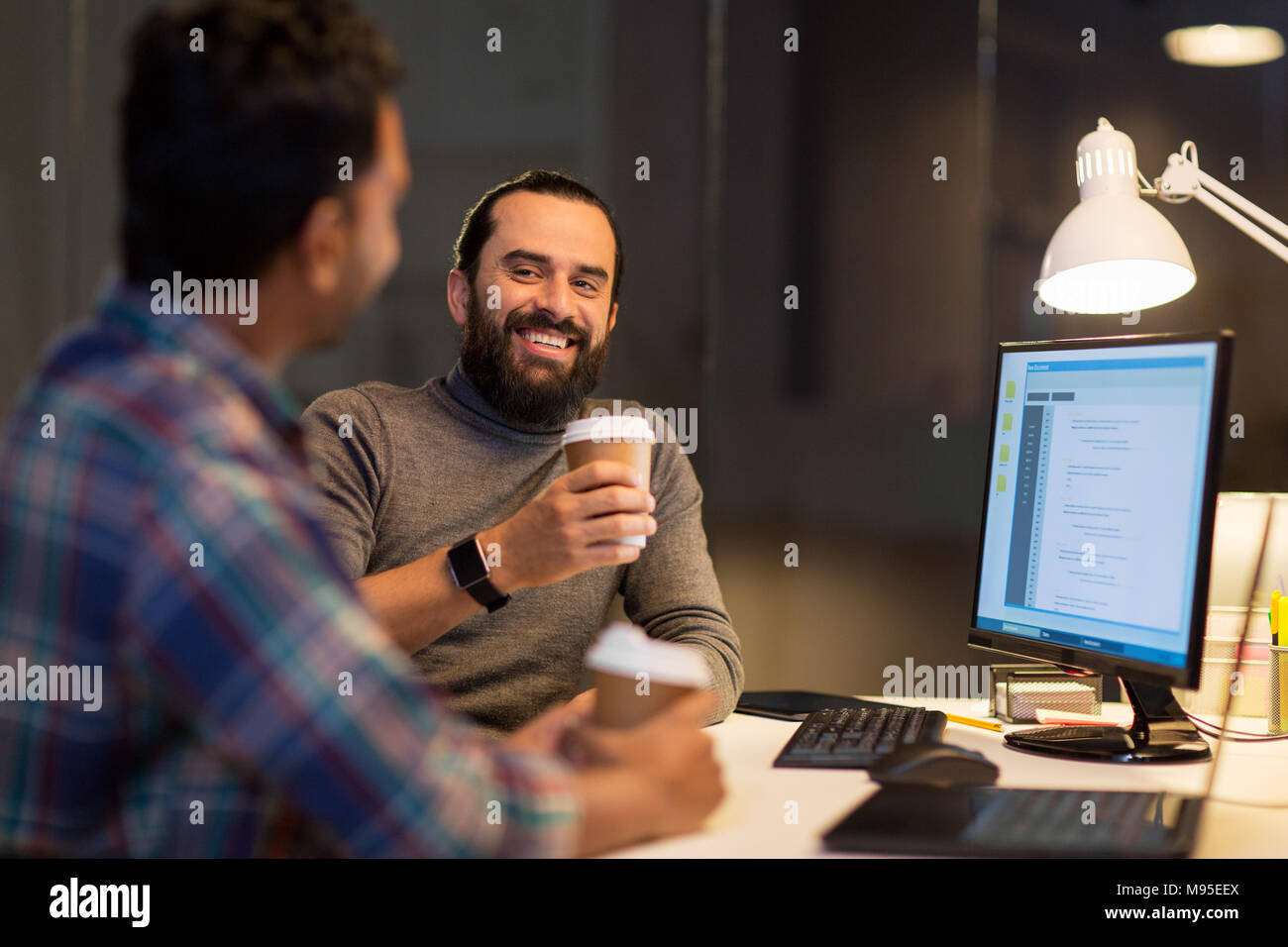 creative team drinking coffee at night office Stock Photo